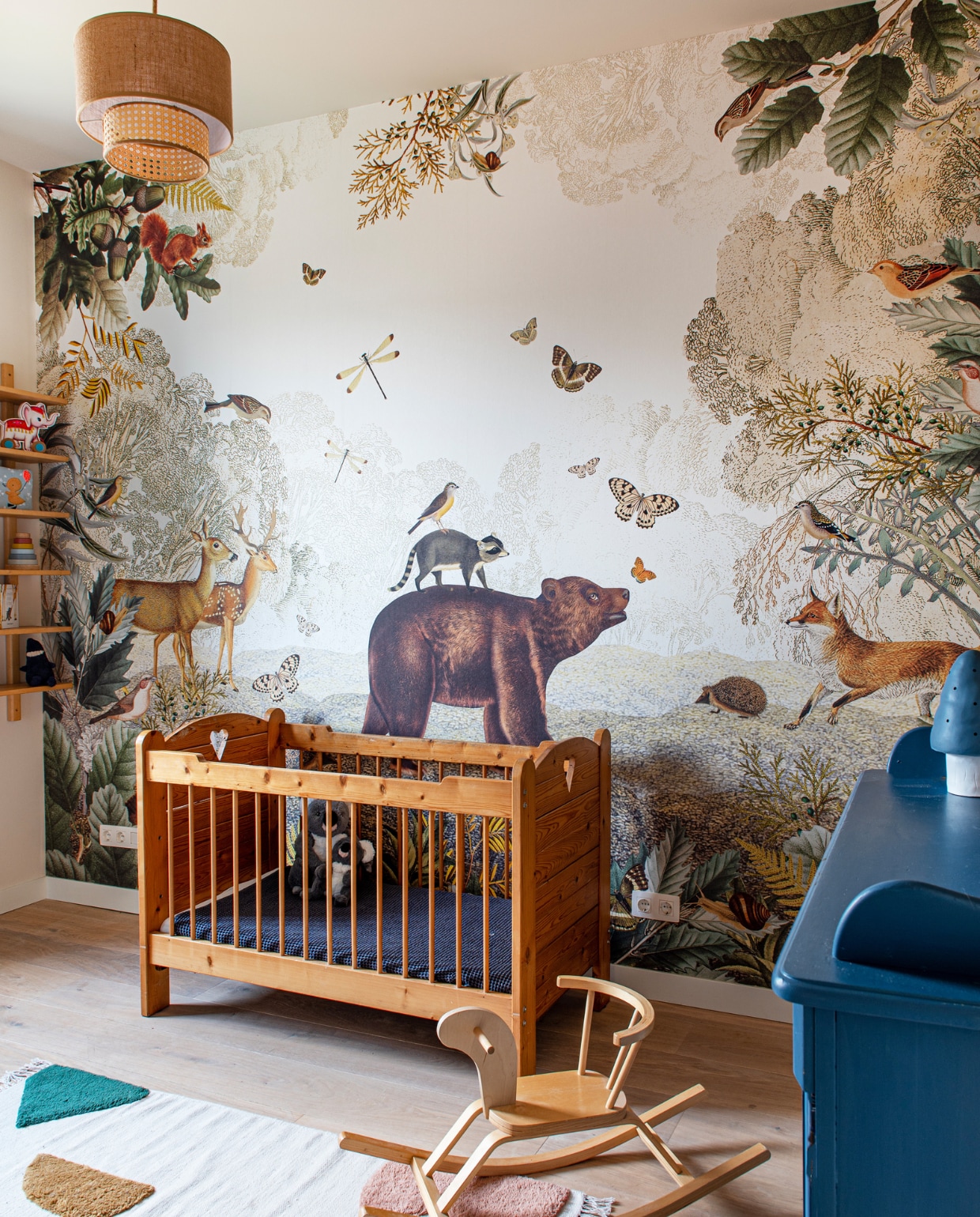 Behang Bosdieren van Pimpelmees. Plafondlamp Home Sweet Home. Ledikant gemaakt door opa. Commode Marktplaats, paddenstoellamp Heico. Vloerkleed Bent Geometric van Liewood, hobbelpaard kringloop. Overig onbekend. vtwonen special binnenkijken 121-2023 | productie De Binnenkijkers | styling Jeske Weel | fotografie Caroline Coehorst