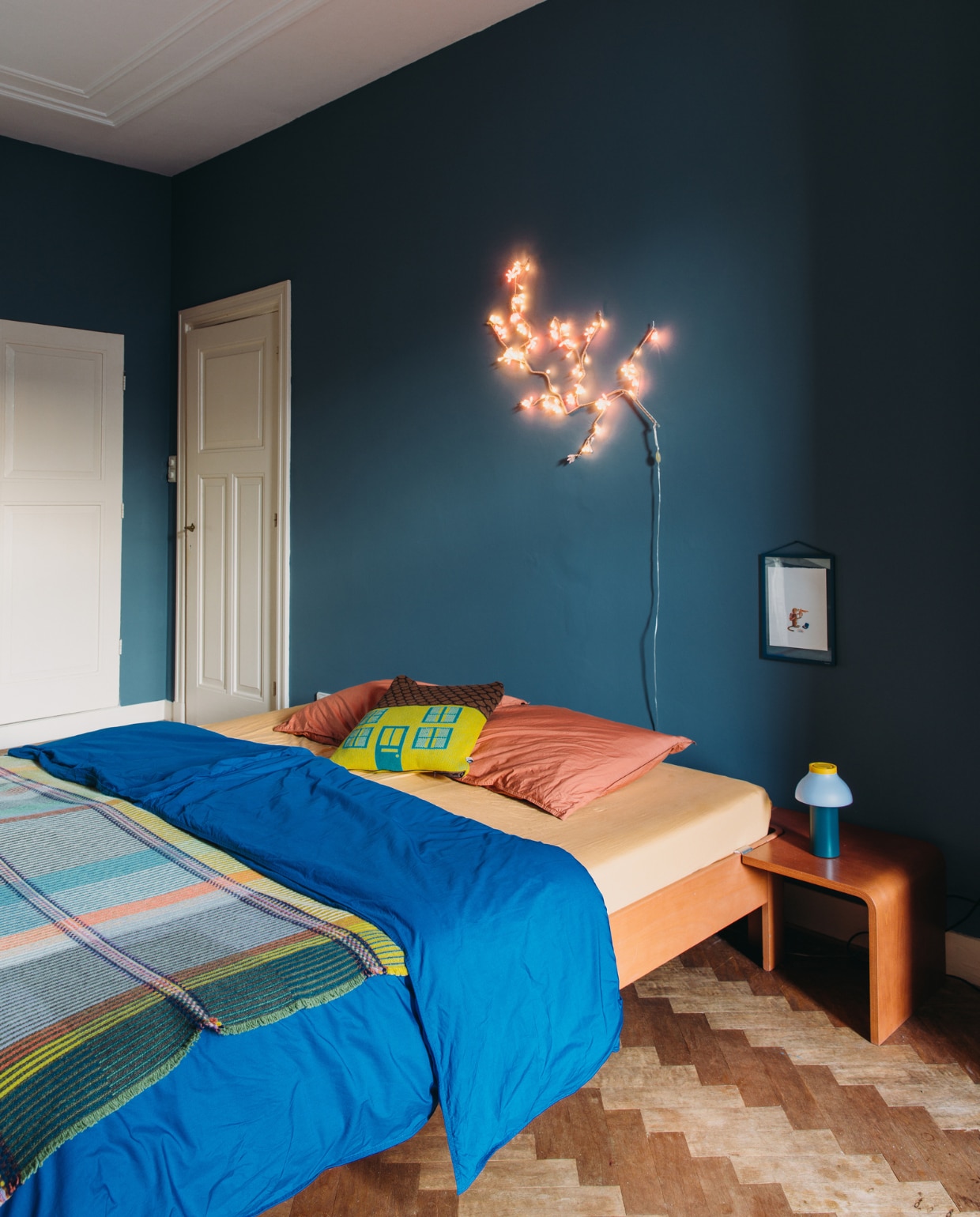Muurverf Hague Blue van Farrow &amp; Ball. Bed Auping, dekbedovertrek Suite702, plaid Wallace Sewell, kussen Donna Wilson. Tafellamp PC Portable van Hay, muurlamp Cherry Blossom Light van Tsé Tsé. Ingelijste tekening Marije Tolman via Moebe. vtwonen special binnenkijken 121-2023 | styling StyleStek | fotografie Eva Bloem
