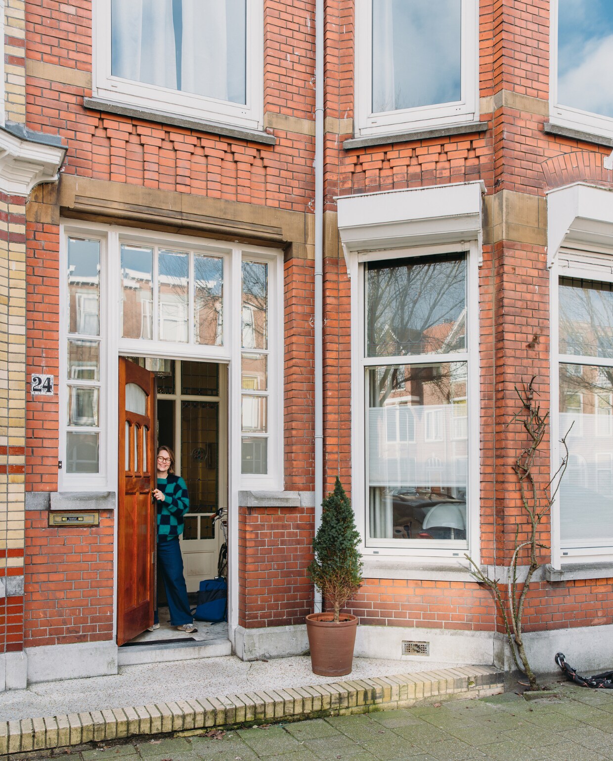 Susan staat in de deuropening van haar 1914 herenhuis in Den Haag. vtwonen special binnenkijken 121-2023 | styling StyleStek | fotografie Eva Bloem