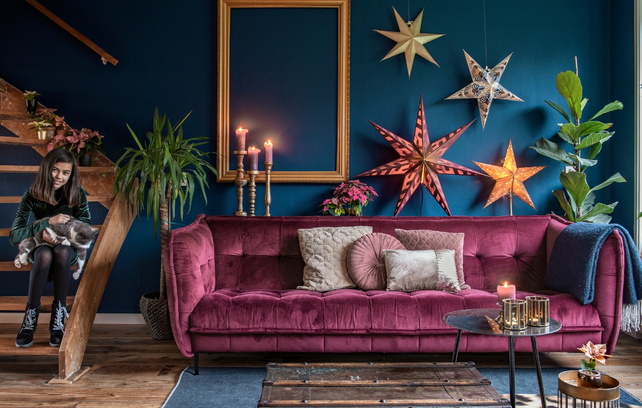 Fluwelen sofa Easy Sofa, oude kist van Mindy’s moeder, zwart tafeltje Leen Bakker, gouden tafeltje Intratuin. Kussens: Jysk (rond), Intratuin (langwerpig) en Be Pure Home. Panter vloerkleed vloerkledenopvinyl.nl en blauw kleed Vloerkledenloods. Papieren sterren Ikea (versierd door Mindy) en Sissy-Boy Homeland (bovenste). Lijst en kandelaars (geverfd door Mindy) van de kringloop. Waxinelichthouders Boer Staphorst, lage kaarshouder kringloop, plantenpotjes Intratuin en kringloop. vtwonen 12-2020 | styling Mindy Schoor | fotografie Ton Brouwer | productie en tekst Monique van der Pauw