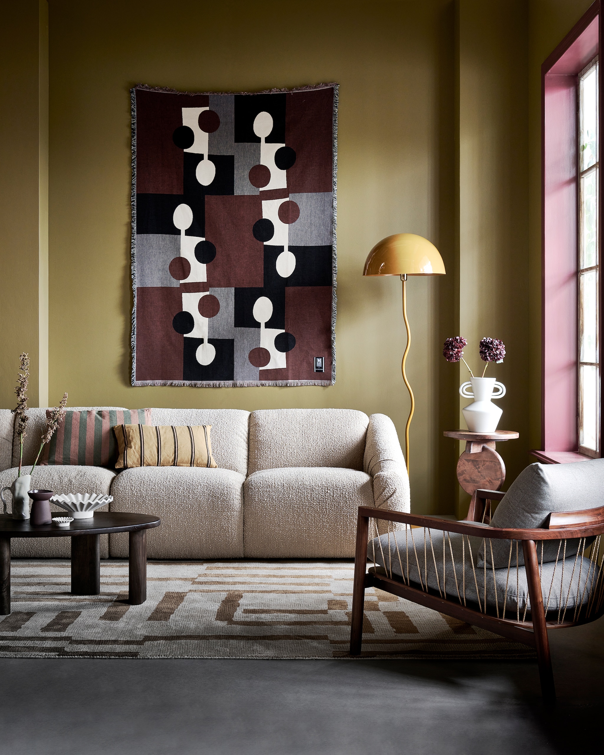 4-zitsbank Cooper, 300x97x72 cm (bxhxd) € 2195,-, metalen vloerlamp Salsa € 149,95, vloerkleed Cato, katoen en polyester, 200x300 cm € 300,- (loods5.nl). Katoenen deken aan de wand Lia van Markslöjd, 130x170 cm € 99,-, mangohouten salontafel 54,8x98,1x34,8 cm (bxdxh) € 329,-, roestbruine keramieken kandelaar € 14,99, witte terracotta vaas, 21,7x30 cm (bxh) € 34,99, keramieken schaal € 34,99, waxinelichthouder € 5,99 (hm.com). Keramieken kan Razan € 29,90 (bloomingville.com). Geel kussen € 14,99 (karwei.nl). Kussen Linen Stripe van By Fonq, katoen en linnen € 34,99 (vtwonen.nl/shop). Fauteuil Enzo in Fabio Stone, walnoothouten frame met polyester bekleding, 71x80x75 cm (bxdxh) € 529,- (sofacompany.com). Mangohouten bijzettafel Nori van Woood, 40x60 cm (Øxh) € 129,- (basiclabel.nl). Muurverf Scented Cumin No. 34 en verf kozijn Merlot Mania No. 123 van Lab Paint, 1 liter € 51,- (vestingh.nl). vtwonen 01-2024 | styling Kim van Rossenberg | fotografie Sjoerd Eickmans | assistentie Minke van Bakel | decorbouw Milo Kol