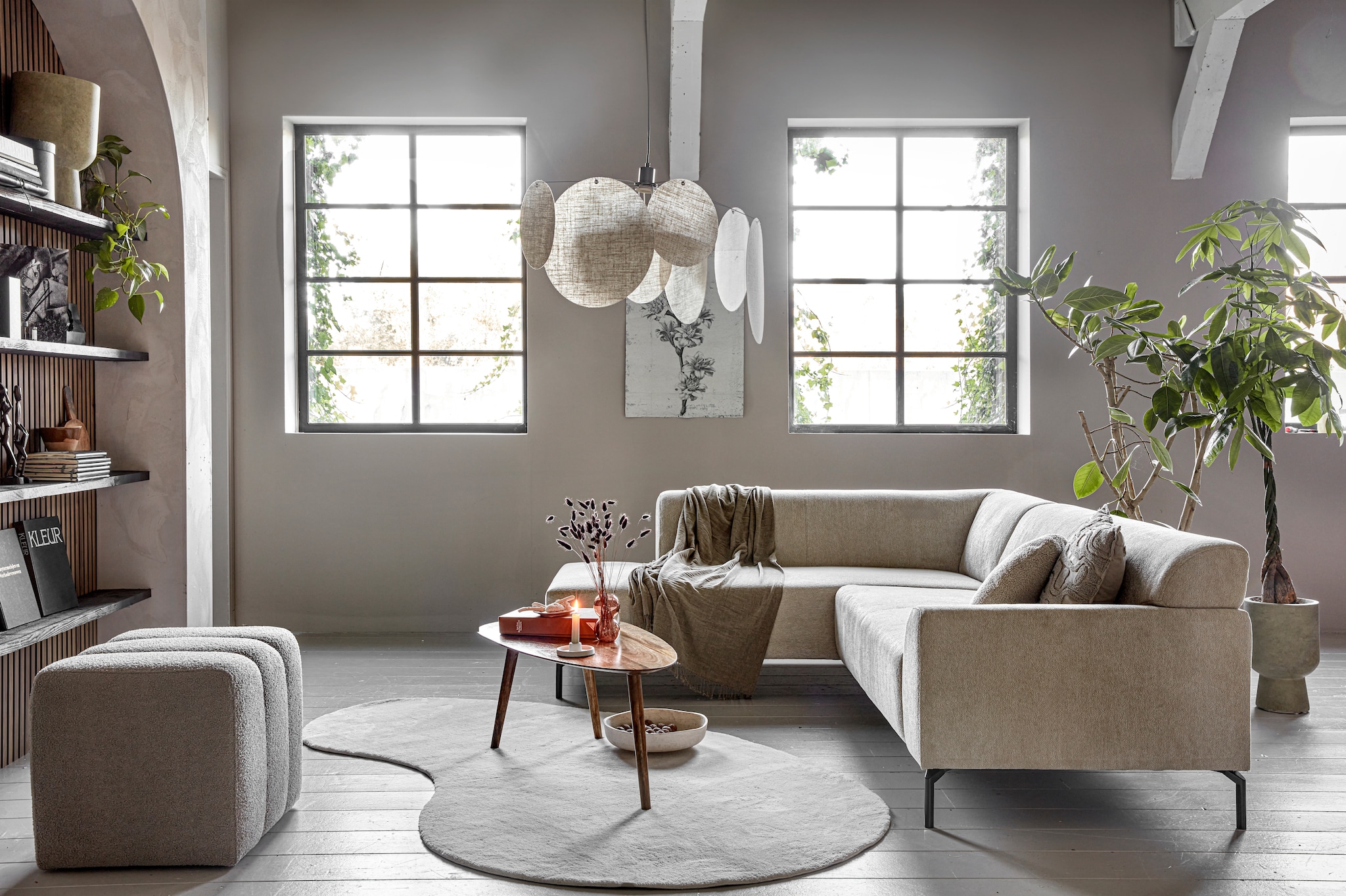 Fsc-gecertificeerde walnoten wandpanelen decor, 60,5x244 cm (bxh), per stuk € 87,82, lakverf Off Black van vtwonen, 1 liter  € 46,99, rond kussen Teddy en taupe kussen, per stuk  € 15,99, grofgeweven poef Erie, 60x50x50 cm (bxdxh) € 159,-, salontafel Kumara € 169,- (karwei.nl). Steigerhouten planken, 250x20x2,3 cm (lxbxh), per stuk € 17,95 (hornbach.nl). Kalkverf Fresco in Sand Storm, 2,5 liter € 129,94 (pure- original.com). Polyester vloerkleed Wells, 140x240 cm € 90,-, groene glazen kandelaars Avie, vanaf € 5,50, glazen bobbelvaas € 9,-, polyester hoekbank Lisio, 256x200x74 cm (bxdxh) € 1095,-, hanglamp Heli, polyester en metaal, 78x120 cm (Øxh) € 99,- (kwantum.nl). Saliegroene bloempot van vezelklei Solvi € 27,50, polyester plaid Dunhavre, 130x170 cm € 17,50 (jysk.nl). Oude foto en kunstboeken, vanaf € 2,50, houten tribalfiguren, per stuk € 6,95, bruin aardewerken schaaltje  € 1,50, broodplank met handvat € 0,50 (kringloopwinkel). Oranje glazen vaas € 8,50, witte kandelaar € 5,- (hema.nl). Keramieken schaal € 18,99 (hm.com). Canvas print € 69,- (mo-cahome.com).  vtwonen 01-2024 | styling Marit Saladini | fotografie Peggy Janssen