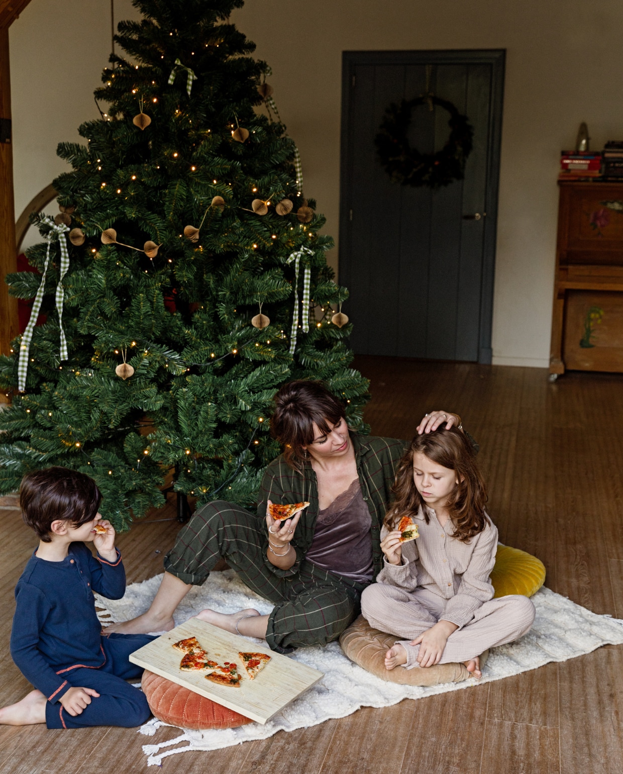 Eva, Lilou en Otis eten een pizza onder de kerstboom in hun 17e-eeuwse boerderij. vtwonen 13-2022 | Styling Ilona Jongepier | Fotografie Dana van Leeuwen
