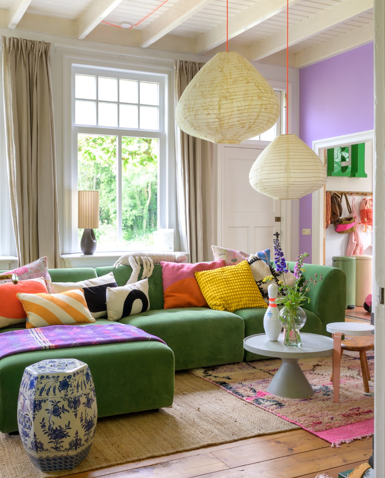 Muurverf WO.20.60 van Flexa. Bank en hanglampen HKliving, kussens Ikea, Fatboy, Urban Nature Culture, Van Verre en kringloopwinkel, plaid Van Verre. Bijzettafels Loods 5 en Gert Snel, kegel Vintage Friends, vaas Urban Nature Culture, krukjes TipToe. Gordijnen Karwei. Vloerkleden Evenaar en WanderWood. Overig onbekend. vtwonen special binnenkijken 12-2023 | fotografie Trui Heinhuis