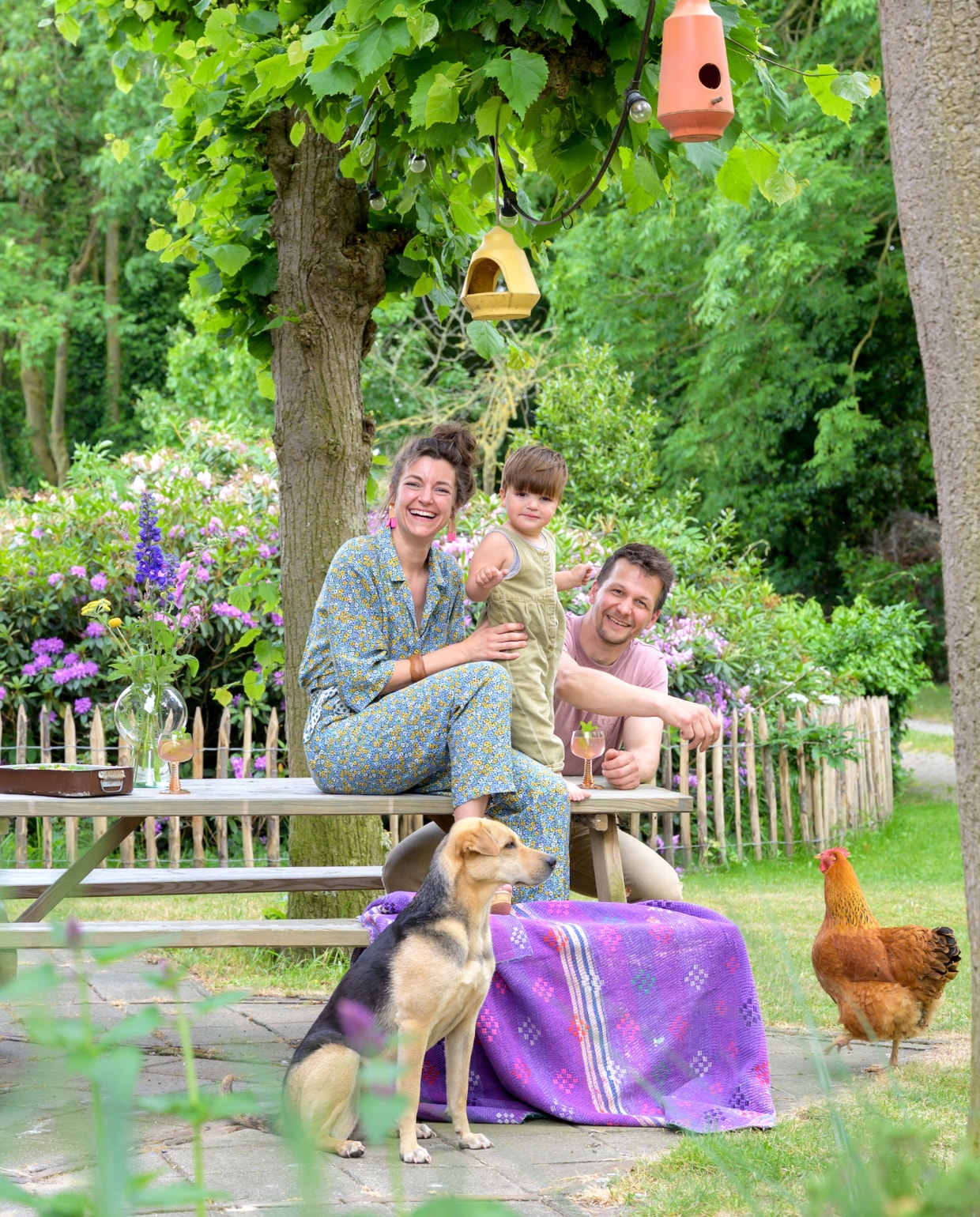 Leonie, Nick en zoon Moos met hun hond en kip in de achtertuin van hun Overijsselse boerderij. vtwonen special binnenkijken 121-2023 | fotografie Trui Heinhuis