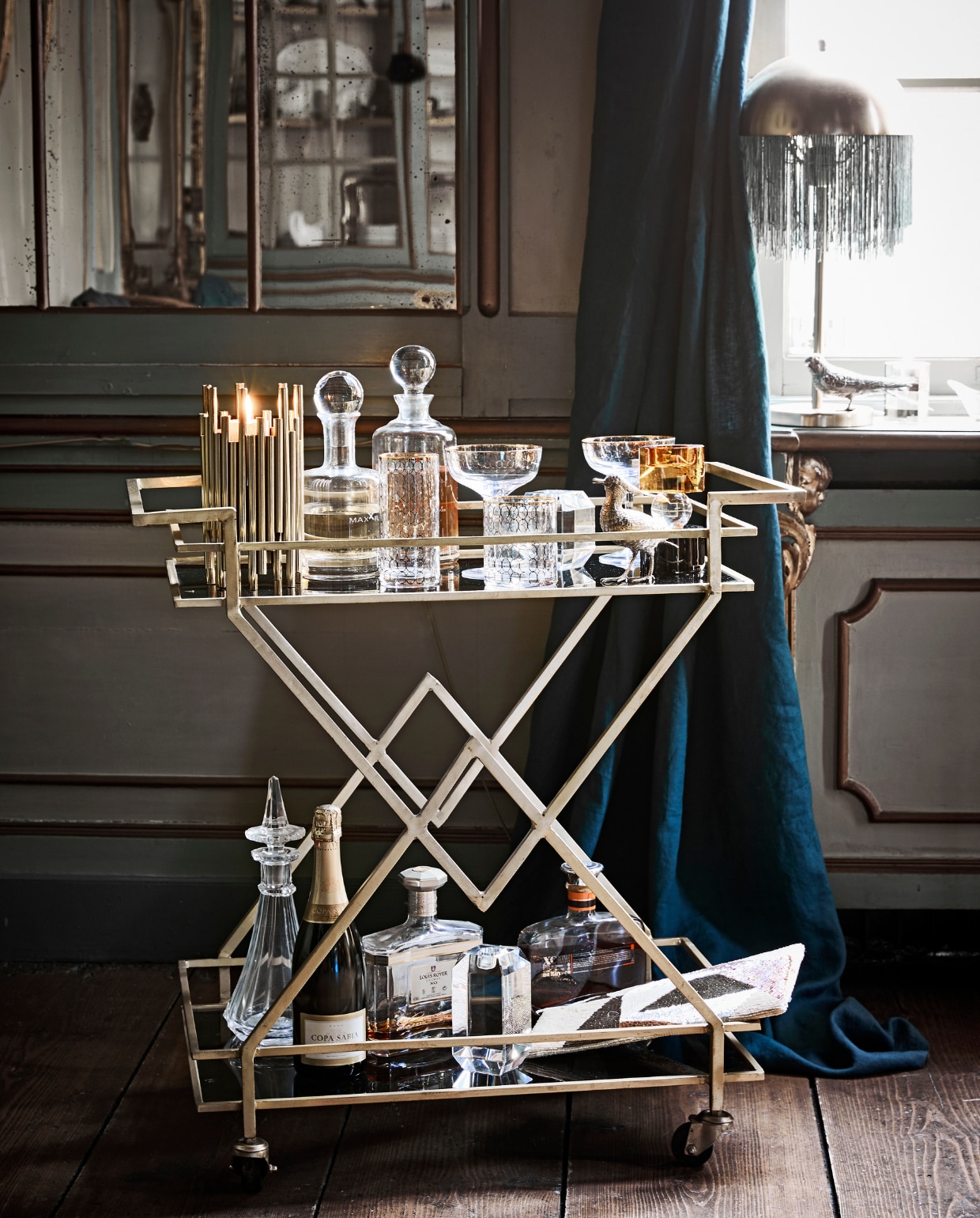 Trolley, cocktailglazen met goud, tafellamp met franjes hoogte 50 cm, avondtasje met kraaltjes, longdrinkglas met goud, laag glas met goud goudkleurige buisjeskandelaar, glazen kandelaar met oker en zwart, helder facet geslepen glazen karaffen (Nordal). Antieke karaffen en oude drankflessen, verzilverde vogels soortgelijk (Prinsheerlijk Antiek). Overig privébezit. vtwonen 12-2018 | styling Cleo Scheulderman | fotografie Jeroen van der Spek | assistentie Mette van der Hoek