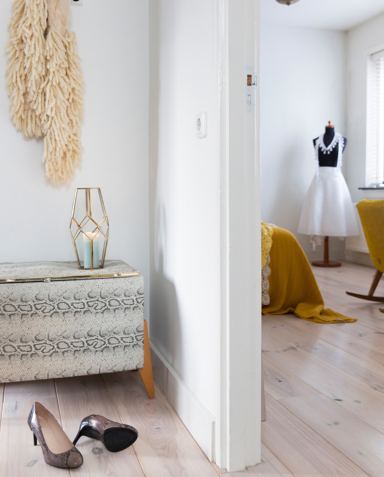 Wollen sjaal Chick on a Mission, dekenkist met slangenprint Berlijnse rommelmarkt RAW Gelände, pumps Marjon Graas Schoenenmode, plafondlamp Zenza Home, paspop rommelmarkt, witte jurk Voo Store. Witte beits vurenhouten vloer Sigma, muurverf RAL 9010. Overig onbekend. vtwonen 13-2022 | styling Barbara Natzijl | fotografie Margriet Hoekstra