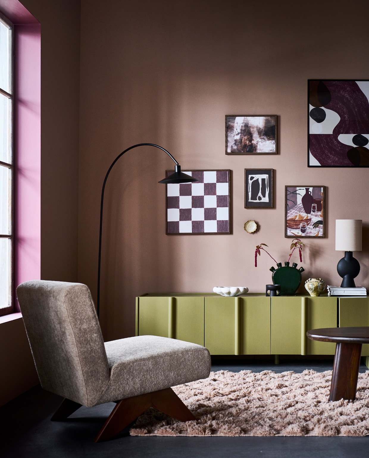 Grenen tv-meubel Basu van Woood in Moss, 200x46x53 cm (lxbxh) € 699,-, tafellamp van Bloomingville, terracotta voet met linnen kap € 115,- (vtwonen.nl/shop). Mangohouten salontafel Roundly van BePureHome, 110x60x40 cm (lxbxh) € 349,- (basiclabel.nl). Fauteuil Marisa, houten poten met polyester bekleding, 62x76x74 cm (bxdxh) € 495,- (loods5.nl). Wolmix vloerkleed, 170x240 cm € 349,-, keramieken schaal € 32,99, keramieken kaarshouder in donkerbruin € 14,99 (hm.com). Keramieken tulpvaas € 14,99, metalen vloerlamp Philou in zwart, 30x100x170 cm (bxdxh) € 79,99 (karwei.nl). Keramieken vaas Cophia € 54,90, poster Yoselin met houten lijst € 67,90, keramieken bord Lilah, set van 2 € 16,90 (bloomingville.com). Poster Checkered Square € 21,95, in houten fotolijst, 50x50 cm € 32,95, poster Tranquility € 18,95, in houten fotolijst, 30x40 cm € 18,95, poster Composition No2 van Lone Fox € 10,95, in houten fotolijst, 21x30 cm € 10,95, poster Wine & Pear Still Life € 18,95, in houten fotolijst, 30x40 cm € 18,95 (desenio.nl). Muurverf Berlin Summer No. 433, verfkleur kozijn Merlot Mania No. 123 van Lab Paint, 1 liter € 51,- (vestingh.nl). Tijdschriften privébezit.  vtwonen 2024-01 | styling Kim van Rossenberg | fotografie Sjoerd Eickmans