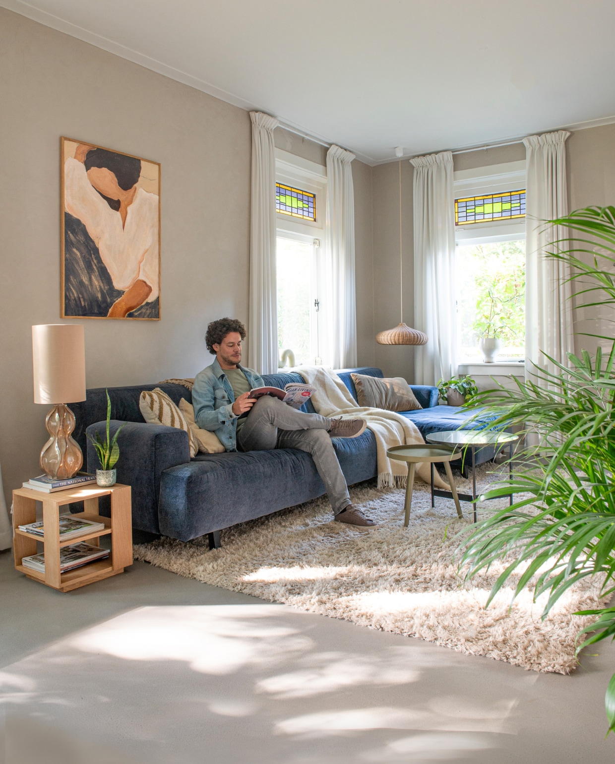 Bank Cartel Living, vloerkleed Kwantum, vierkante bijzettafel Hübsch, tafellamp House Doctor, rotan hanglamp Ferm Living, gordijnen Gamma, plaid Arket, muurverf Mushroom van Lab Paint, topvloer woonbeton van Coatingvloer.nl, print Silent Dreams van Paper Collective, gestreept kussen Wehkamp, groen kussen HKliving, groene bijzettafel Dutchhome, zwarte bijzettafel Live Today. Overig onbekend. vtwonen 01-2024 | productie De Binnenkijkers | styling Jeske Weel | fotografie Caroline Coehorst