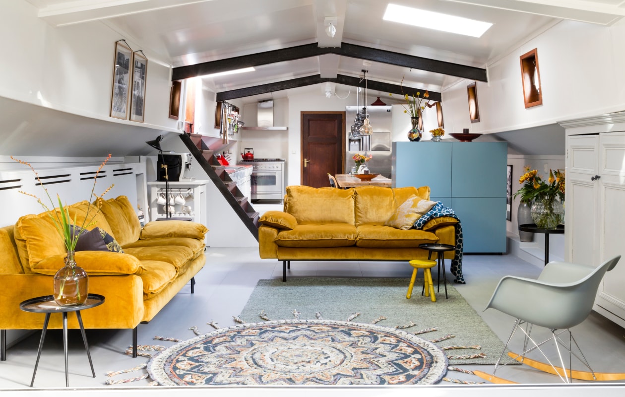 Pvc vloer Moduleo Desert Stone (woninginrichting-aanhuis.nl). 4-zitsbank Retro van HK Living, fluweel in kleur oker, poten zwart metaal, 245x83x95 cm (bxhxd), 2-zits 175x83x95 cm (bxhxd), rond wollen vloerkleed Pix van Dutchbone, Ø 170 cm (vtwonen.nl). Op bank kussen Olive Fortunata, kussens op loungebank v.l.n.r. Caramel Eclectic, grijs gebloemd Fortunata, Iced blue, mintgroen Reemondo, Acadia Gold, Dafne, mintkleurig (eijerkamp.nl). Stof kussens in de loungehoek privébezit. vtwonen weer verliefd op je huis seizoen 9 aflevering 5 | styling Frans Uyterlinde | fotografie Barbara Kieboom