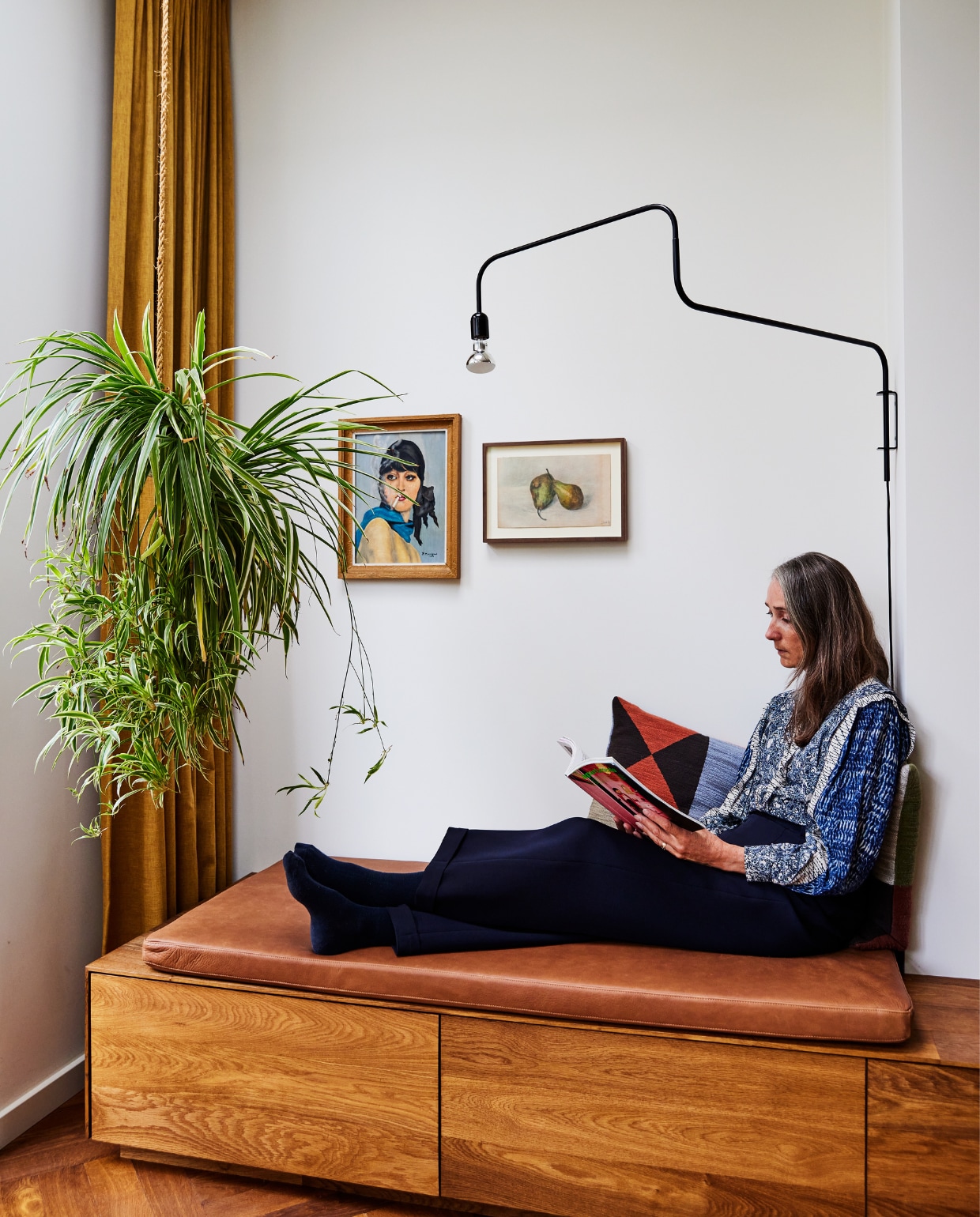 Lamp en houten wandbank ontworpen door X+L, bank Schriever Interieurbouw. Leren kussen en gordijn Links &amp; Co. Schilderijen vintage. vtwonen 11-2023 | styling Mariella Kallenberg | fotografie René Mesman