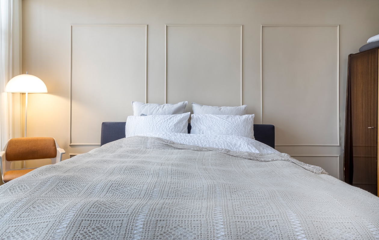 Muurverf Gentle Cotton van Bierens. Lamp vintage Space Age. Vintage jaren 60-stoel Gispen. Bed Auping, dekbedovertrekIkea, sprei onbekend. vtwonen 08-2022 | styling Kesslee Kasius | fotografie Henny van Belkom
