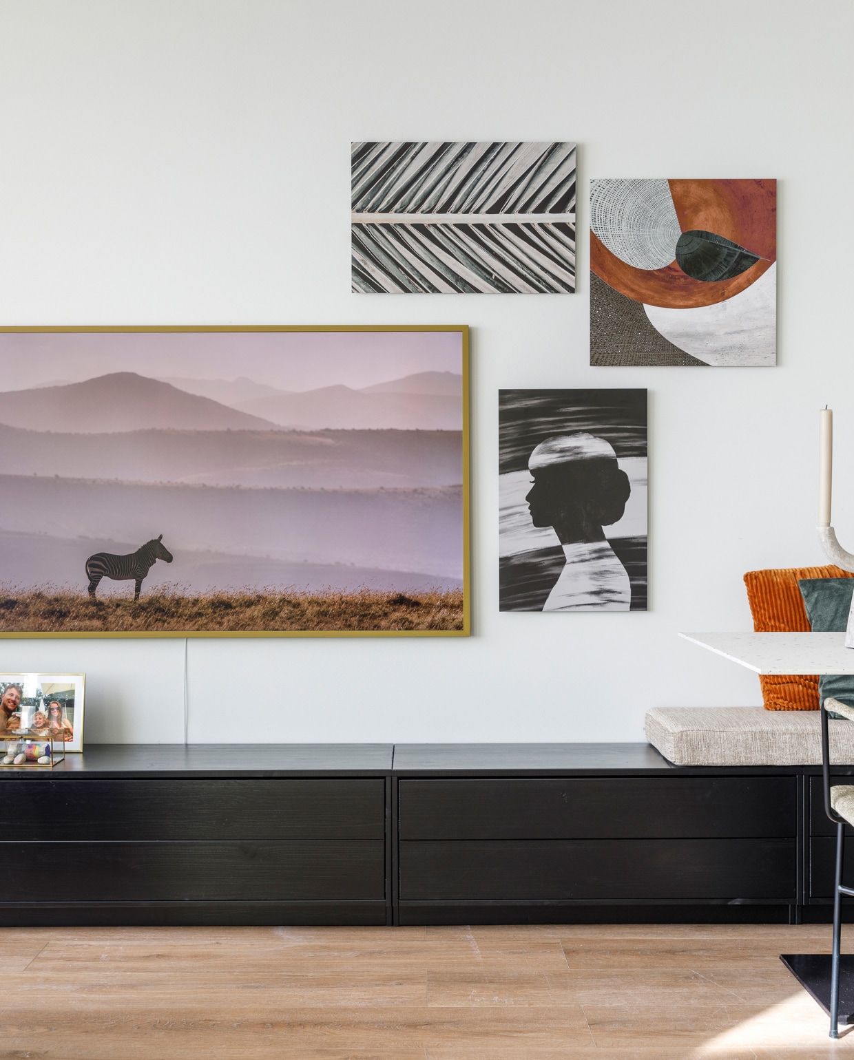 Flexa Creations muurverf Misted Grey (flexa.nl) Tv The Frame met lijst in kleur Forest (samsung.com). Kunstwerk Palmblad_005 1x Studio III, kunstwerk Geomix 29c2b van Aimelle ML, kunstwerk Modern abstract portret vrouw zwart-wit van Studio Hinte. Tv-meubel en zitbank ineen in kleur Deep Black (eijerkamp.nl). Op maat gemaakt zitkussen en kussen in stof Hawk in kleur Seagrass (nofruit.nl). Gouden glazen box (housevitamin.com).  Overig privébezit. Weer verliefd op je huis aflevering 10 seizoen 17 | styling Eva van de Ven | fotografie Margriet Hoekstra