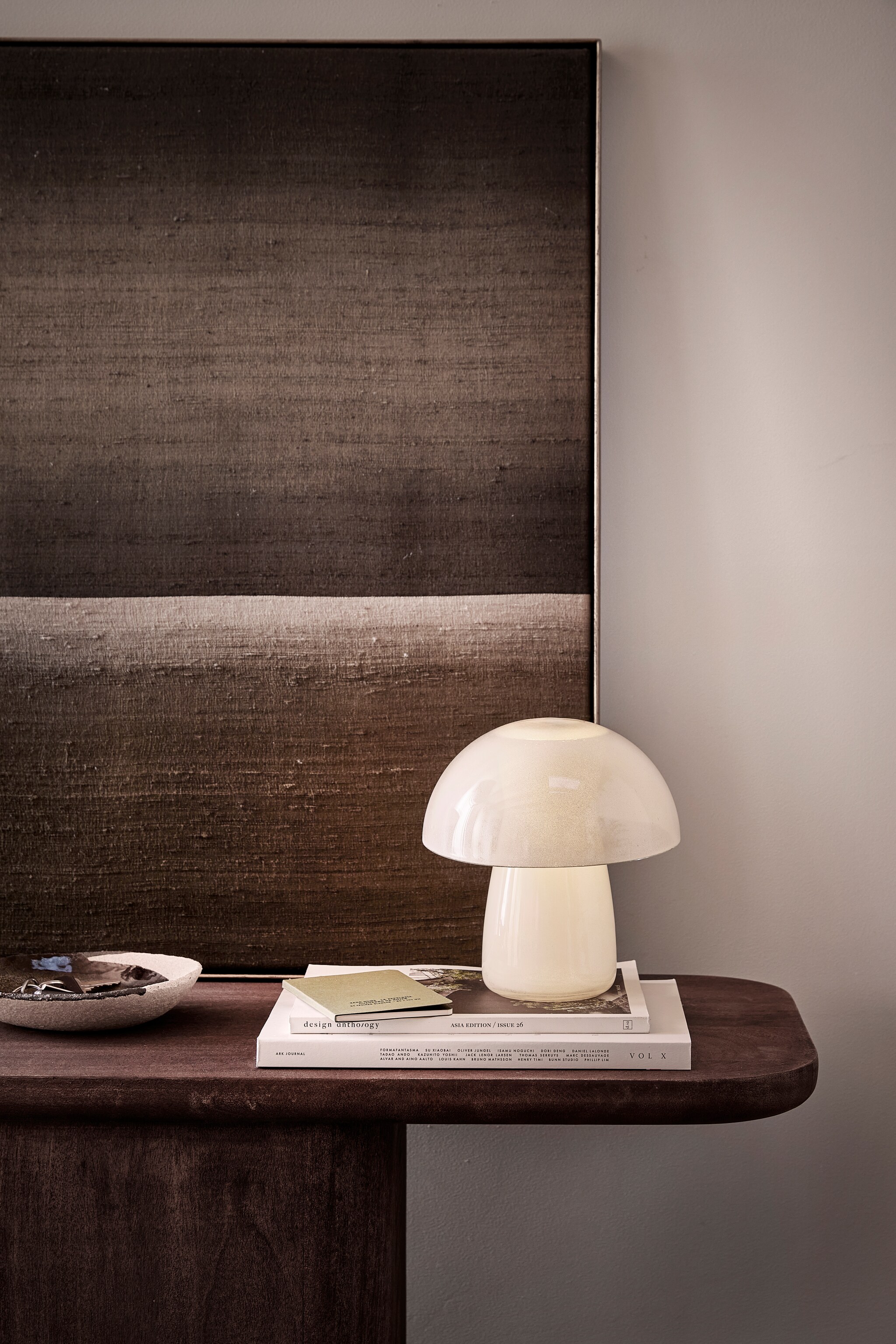 Tafellamp gemaakt van glazen serveerschaal Blanda € 1,99 en glazen karaf Karaff € 1,29 (ikea.com). Mangohouten sidetable Toke, 120x40x80 (bxdxh) € 1704,55 (nordal.com). Notitieboek € 7,99 (zarahome.com). Overig privébezit. vtwonen 02-2024 | styling Sanne Ketelaar | fotografie Peggy Janssen