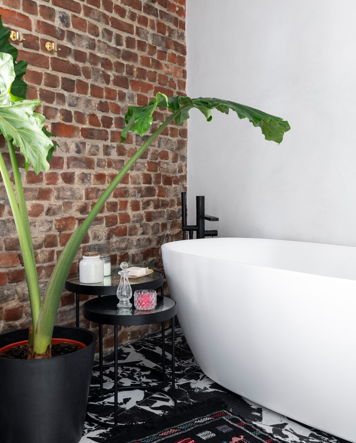Vloertegels B&amp;W Marble. Ligbad en kranen X2O. Bijzettafels Pomax, accessoires reissouvenirs. Overig onbekend. vtwonen 121-2023 | styling Amélie Jacob | fotografie Jonah Samyn