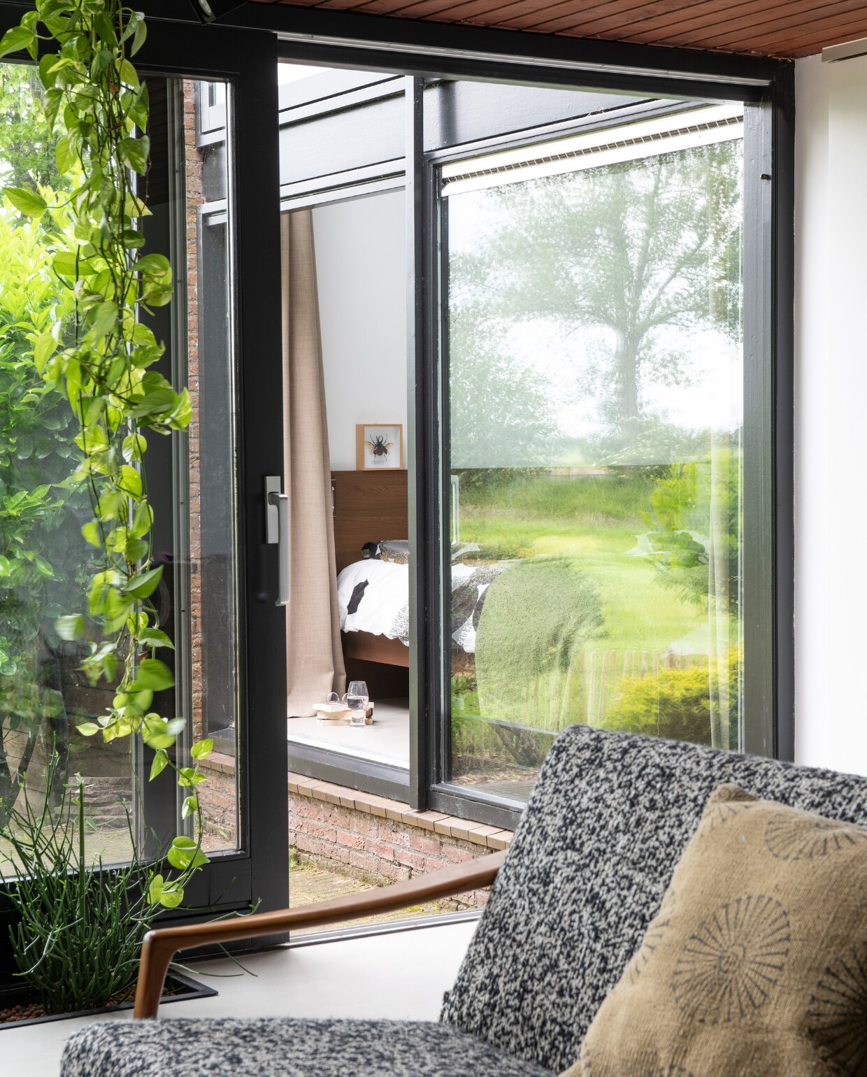 Zowel de huiskamer als de slaapkamer heeft een schuifdeur naar de tuin. Kussen Karwei. vtwonen 01-2020 | styling Kim Timmerman/Insidehomepage | fotografie Louis Lemaire