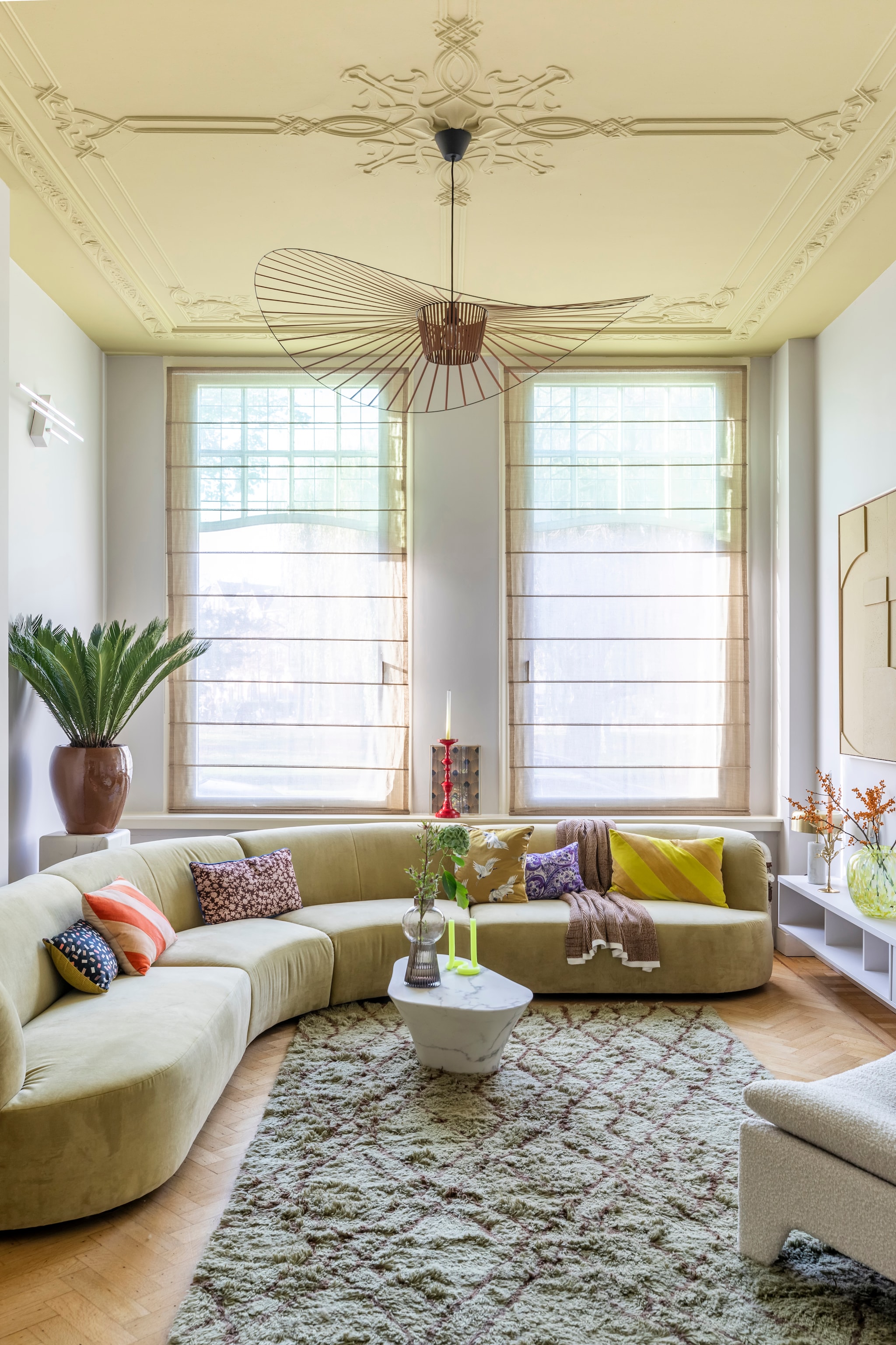 Flexa Creations muurverf op de muren Steady Pebble, op het plafond Cornflower Field (flexa.nl). Tv-meubel op maat gemaakt prijs op aanvraag (remmers-design.nl). Televisie The Frame met lijst in de kleur Forest uit de vtwonen collectie prijs op aanvraag (samsung.com). Lichtobject aan de muur gemaakt door Ontwerpduo € 1100,- (aptumlighting.com). Bank Faith € 4499,-, marmerlook tafel van Pols Potten € 578,50, vloerkleed van HKliving € 895,-, plafondlamp van Petit Friture € 795,-, vloerlamp van HKliving € 449,-, marmeren sokkel van Pols Potten € 345,-, geelgroen kunstwerk Relief van HKliving € 625,-, fluwelen kussens met diagonale strepen van HKliving, per stuk € 34,95, tafellamp links op het tv-meubel van Lucide € 114,95 (eijerkamp.nl). Fauteuil Retro Lounge van HKliving € 795,-, rechthoekige kussens met vintage dessin van Doris for HKliving, per stuk vanaf € 32,95, geel kussen met vogels van Vestbjerg € 19,95, plaid van Marc O’Polo € 129,-, vaas op de salontafel van Bloomingville € 43,50, gele vaas van Vase The World € 109,-, rode kandelaar van Pip Studio € 44,95, lijsten uit de vtwonen collectie, per stuk vanaf € 22,95, gouden kandelaar van Pols Potten € 99,- (vtwonen.nl). Kaars Twist vanaf € 25,- (lexpott.nl). Overig privébezit. vtwonen weer verliefd op je huis | seizoen 13 aflevering 12 | styling Marianne Luning | fotografie Margriet Hoekstra