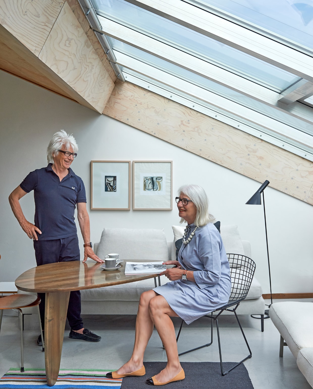 Aart en Greetje in hun bovenwoning in Amsterdam op het KNSM-eiland. Tafel van Isamu Noguchi (Vitra), draadstoel van Harry Bertoia (Knoll), staande lamp AJ van Arne Jacobsen (Louis Poulsen), kunst van Bram van Velde, kruk en lopers Ikea. vtwonen special binnenkijken 03-2020 | styling Rob Jansen | fotografie Dennis Brandsma