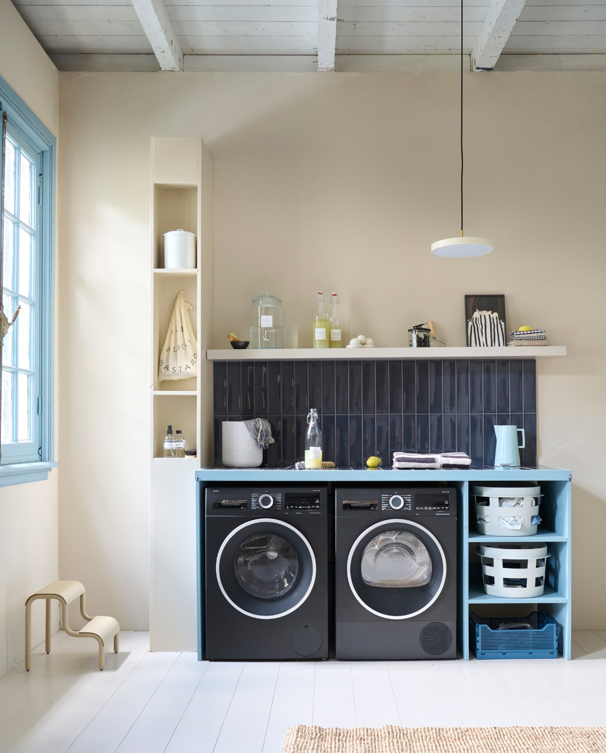 Lakverf wasbar Old Blue van vtwonen, 500 ml € 20,99, muurverf Warm White van vtwonen, 1 liter € 27,99 (karwei.nl). Lakverf kozijn Wit Golven, 500 ml € 30,99 (flexa.nl). Tegels Shapes van vtwonen in Titanium Blue Glans, 30x7,5 cm, per m2 € 59,- (go.vtwonen.nl/collectie)  Lamp Asteria van Umage € 179,45, kunststof wasmand van Hay € 39,-, metalen kruk van Ferm Living € 139,-, katoenen handdoek van HKliving € 49,-, katoenen mand van Ferm Living, set van 3 € 269,- (vtwonen.nl/shop). Emaillen blik € 9,95 (dille-kamille.nl). Wasmachine € 1069,-, warmtepompdroger € 1149,- (bosch-home.nl). Houten plank Lack € 29,99 (ikea.nl). Print Shy € 35,- (mydeerartshop.nl). Aardewerken kan Dik € 39,- (hollanddesignandgifts.com). Flessen linksonder in kast vanaf € 19,50 (marie-stella-maris.com). Flessen wasmiddel, pag. 44. Kleed Lohals, € 72,95 (ikea.nl), pag 34.Overig privébezit. vtwonen special DIY 8-2023 | styling Kelly van Gendt, Corrien Flohil | uitvoering Erik de Jong | fotografie Sjoerd Eickmans