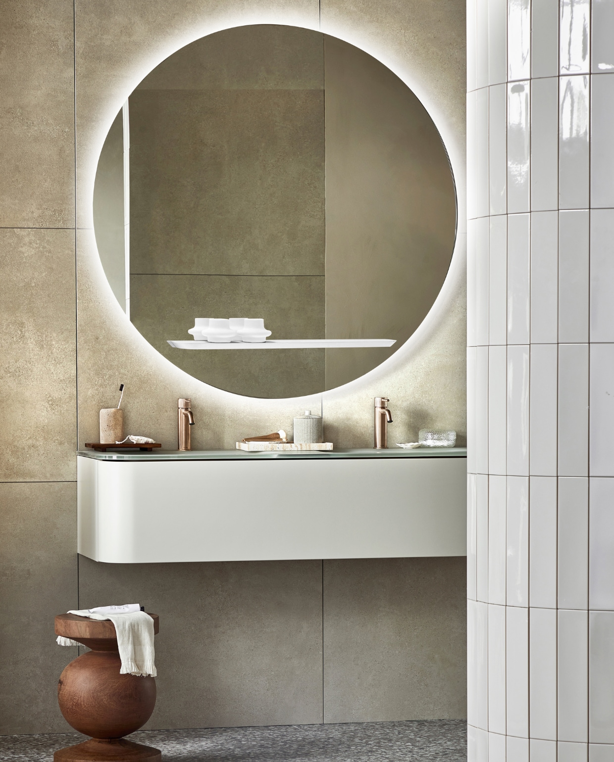 vtwonen collectie (spiegel Reflect, inclusief ledlicht en condensvrij, 120 cm (Ø). Top solid onderkast Bend in Zand met push to open-systeem, 130x48x31 cm (bxdxh). Vloer: vloer- en wandtegel Terrazzo Clay Flakes, 90x90 cm. Achterwand: vloer- en wandtegel Raw Sand Mat, 80x80 cm. Op de ronde wand: wandtegel Shapes Vapor glans). M.m.v. plieger.nl (wastafelkranen Roma), polspotten.nl (houten kruk), zarahome.com (travertin tandenborstelhouder, houten dienblad, travertin dienblad, pot met deksel, kwasten, kleine witte schaal, tube crème), hm.com (handdoek, badmat, glazen doosje). Overig privébezit. vtwonen 05-2023 | productie Tanja Saarberg | styling Sanne Ketelaar | fotografie Peggy Janssen