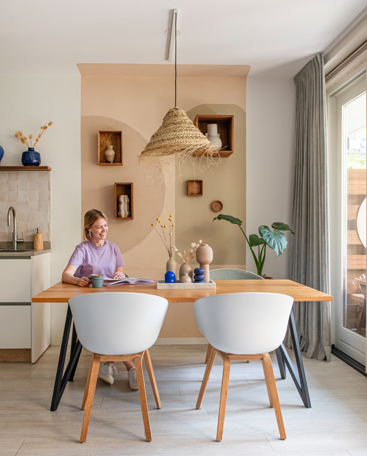 Tafel Studio Henk, gestoffeerde kuipstoelen Hay, hanglamp By Bamboo Beach Living. Wandkasten Bolia en H&amp;M Home. Keuken Häcker, tegels The Mosaic Factory, blauwe vaas Intratuin. Muurkleuren zelf gemengd. Overig onbekend. vtwonen 01-2024 | fotografie Caroline Coehorst