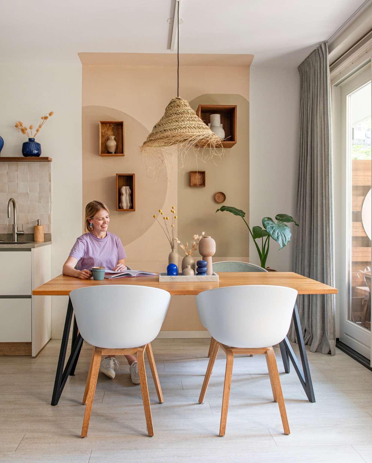 Tafel Studio Henk, gestoffeerde kuipstoelen Hay, hanglamp By Bamboo Beach Living. Wandkasten Bolia en H&amp;M Home. Keuken Häcker, tegels The Mosaic Factory, blauwe vaas Intratuin. Muurkleuren zelf gemengd. Overig onbekend. vtwonen 01-2024 | fotografie Caroline Coehorst