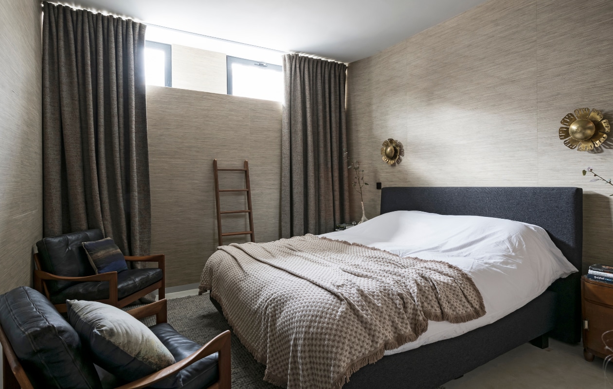 Behang Karine Bonjean, gekocht bij haar. Dikke wollen gordijnen laten maken met stoffen van Moodz Designculture. Bed Ambertree. Deken uit Brazilië, gekregen van haar vriend. Ladder van Made by Hand. Vintage lampen Modest Furniture. Stoel en kussen HKliving vtwonen 10-2020 | styling Caroline De Cuyper | fotografie Jonah Samyn