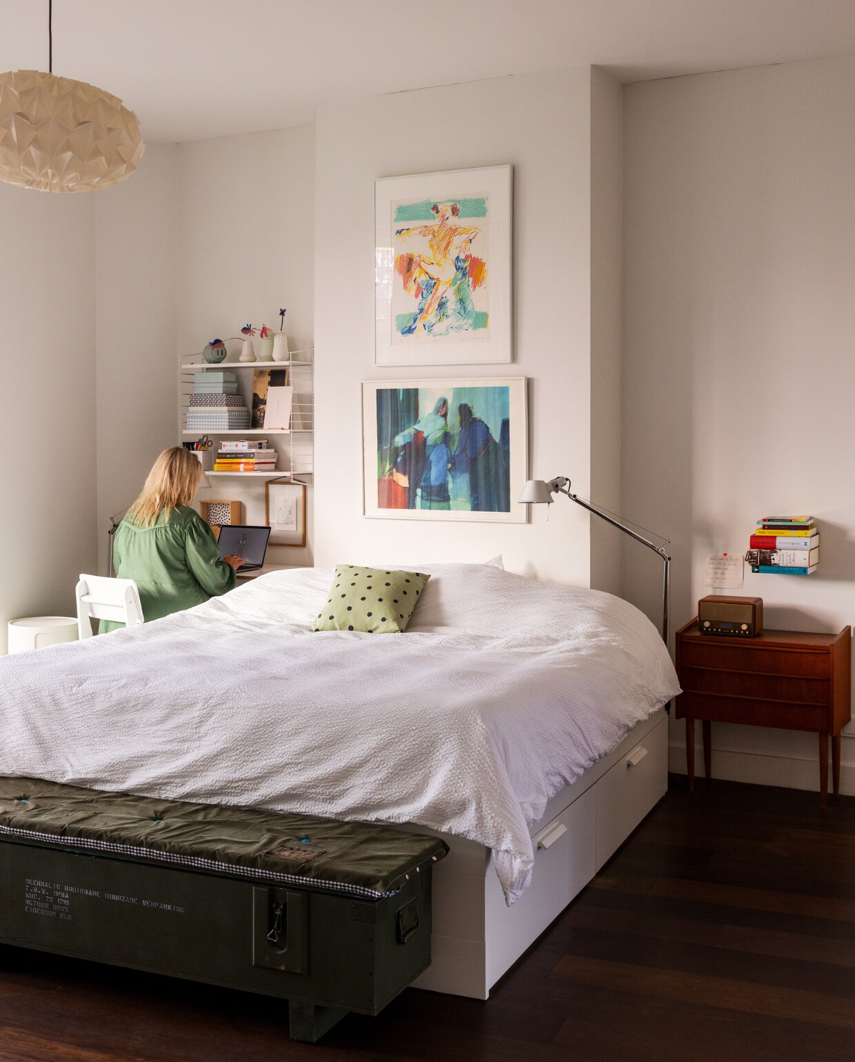 Kunstwerken van Robert Terwindt en Gerard van den Berg. Vloerlamp Artemide, hanglamp Studio Snowpuppe, vintage nachtkastje Tomado, bed Ikea met matras van Eve, beddengoed Crisp Sheets, stoel Crisis van Piet Hein Eek, zwevende boekenplank Ceci n’est pas un livre, legerkist Combitex, kussen gemaakt van oude legerstof, wandrek Marktplaats. Vazen Hella Duijs en Store Without a Home, radio Nieuws Innoventions, rond nachtkastje Kartell. vtwonen 01-2024 | styling Ilona Jongepier | visagie Djolien de Kreij | fotografie Dana van Leeuwen