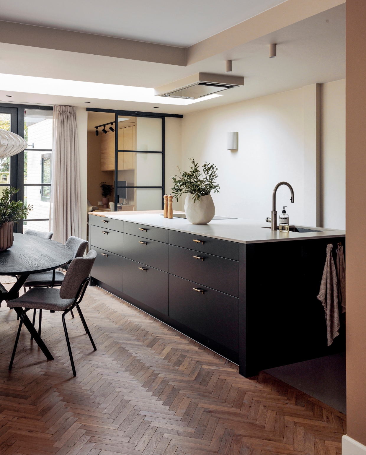 Keuken Keur Keukens, schuifdeur GewoonGers, vloer Loven Tapis van De Woonzaken, eettafel Ramses van Bodilson, eetkamerstoelen Patch van Bodilson, wandlamp Hilko van Westwing Collection. Muurkleur Crushed Silk van Histor, gordijnen Jorrit van Kwantum. Peper-en-zoutstel Loods 5, vaas zelfgemaakt. Kasten kantoor Ivar van Ikea. vtwonen 01-2024 | fotografie Ernie Enkelaar
