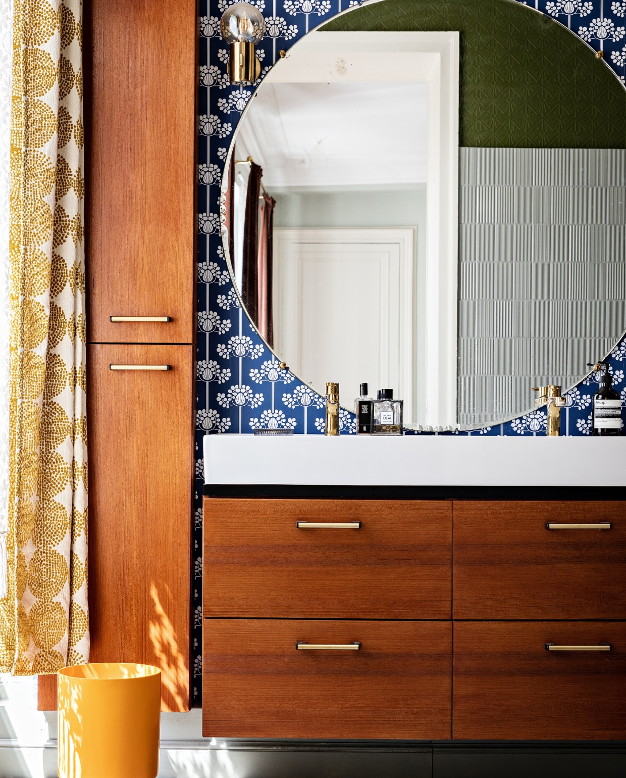 Behang Etoffe. Badkamerkasten Ikea met teakhouten fronten erop bevestigd. Antieke spiegel Carouche. Wandlampen en seventies-prullenbak vintage. Overig onbekend. vtwonen special binnenkijken 03-2022 | productie AC Scoffoni | styling Marie-Maud Levron | fotografie Yann Deret