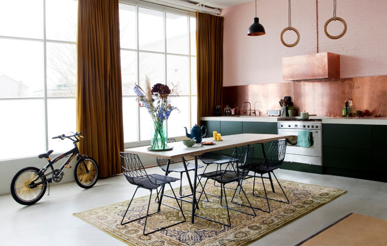 De keuken is van Sense Keukens, het betonnen aanrechtblad heeft Erika laten gieten. Fornuis van Smeg, koelkast van Samsung. De eettafel heeft Erika op maat laten maken met een berkenmultiplex en linoleum blad en onderstel van Ikea. Eetkamerstoelen Loods 5. Hanglampen van Smartwares. De Japanse Tatami mat komt van de kringloop. De Troy Fire Dragon fiets is van Braz. Vloerkleed van Louis De Poortere vond Erika bij de IJ-Hallen in Amsterdam-Noord. De schuifdeuren zijn origineel en kunnen helemaal worden geopend. De aannemer maakte het betonnen aanrechtblad. vtwonen 08-2018 | fotografie Jeltje Janmaat | styling Erika Vocking