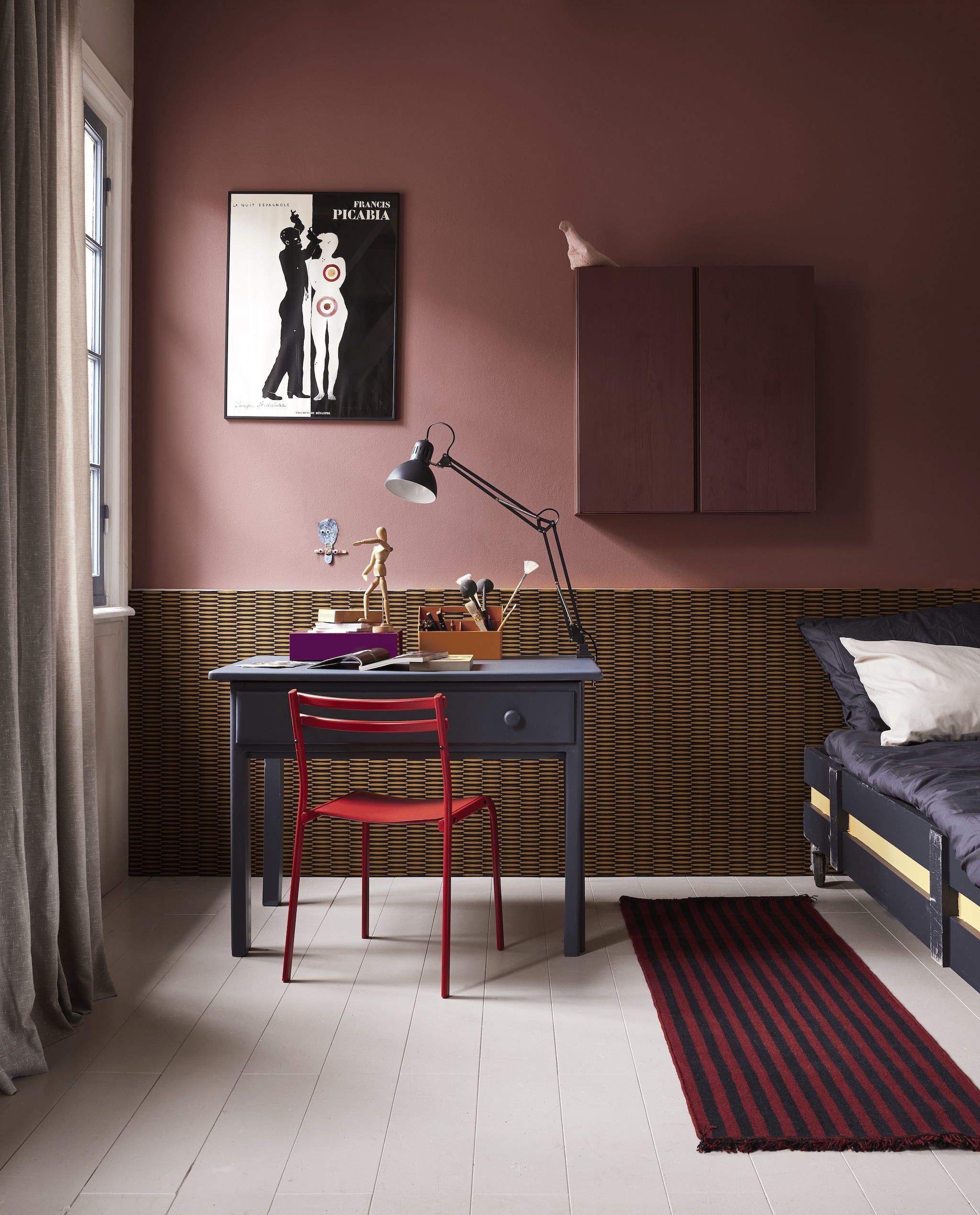 Muurverf Famous Rouge van Lab Paint, lakverf tafel Hero?s Time van Lab Paint, lakverf gele streep bed Bumblebee van Lab Paint, lakverf wandkast Merlot Mania van Lab Paint (vestingh.nl). Behang Ombra in Kente Curry, 0,55x10 m (bxl) (masureel.com). Houten tafel, 115x70x78 cm (bxdxh), houten bed (com-anders.nl). Houten wandkast Ivar, 80x30x83 cm (lxbxh), metalen bureaustoel Genesn, stalen bureaulamp Tertial, beige katoenen kussensloop Dvala (ikea.nl). Paarse kartonnen opbergdoos, wollen vloerkleed Stripes and stripes in Cherry, 200x60 cm (hay.nl). Toolbox Sketch van Muuto, gerecycled plastic (groenenakker.nl). Zwart katoenen dekbedovertrek van Ambiante, 140x200 cm (vtwonen.nl/shop). Overig privbezit.