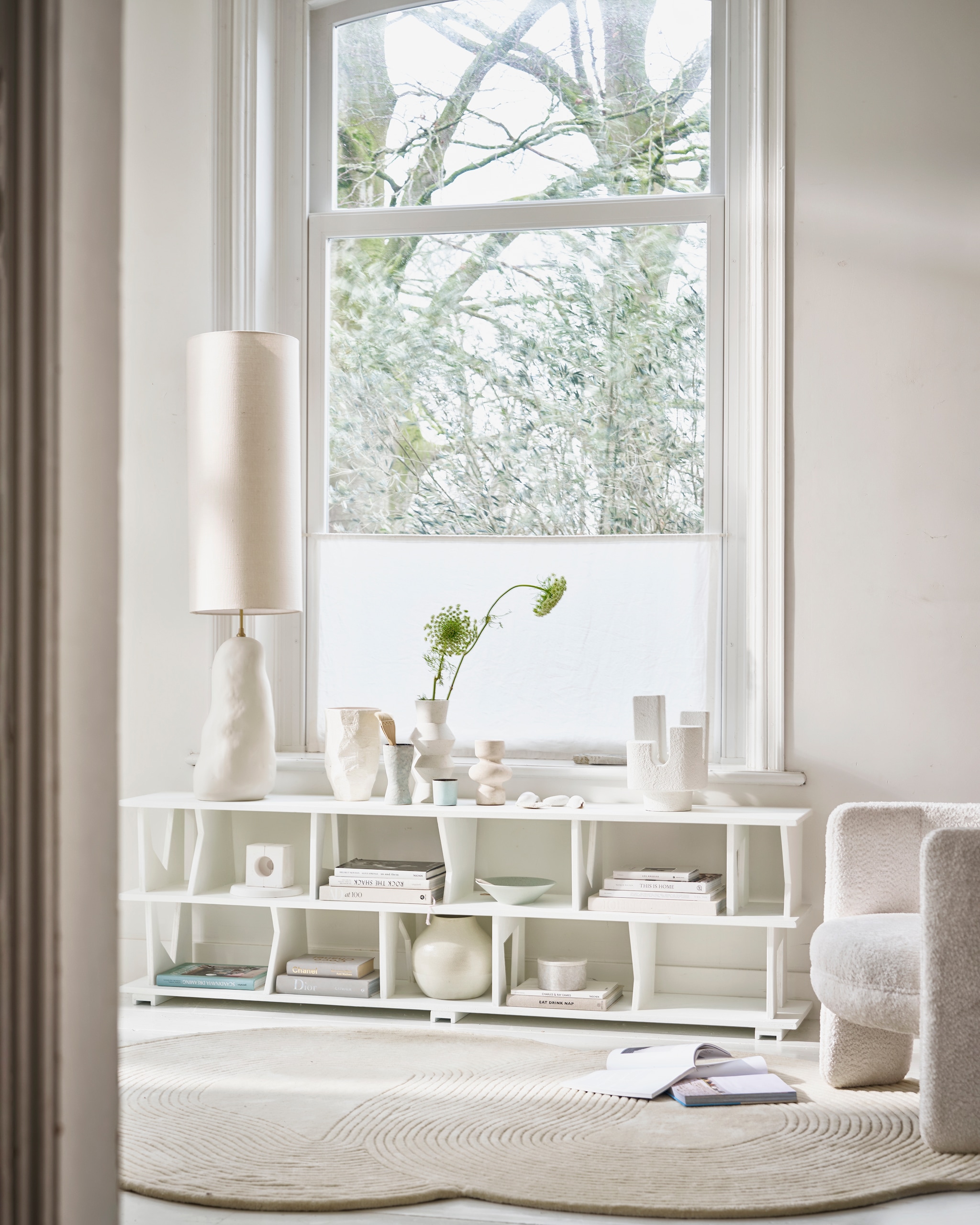 Kast maatwerk, prijs op aanvraag (com-anders.nl), geverfd in Strong White 2001 van Farrow &amp; Ball, 750 ml € 52,- (paint-paper.nl). Keramieken lampenvoet Hebe in off-white, 23x100 cm (Øxh) € 379,-, linnen lampenkap Eclipse van Ferm Living, 30x80 cm (Øxh) € 175,-, vloerkleed Zen van Bolia, wol en katoen, 180x240 cm € 1294,-, keramieken beker Terres de Rêves van Serax in Smokey Blue € 15,95 (vtwonen.nl/shop). Keramieken vaas Serra € 69,95, keramieken tafellamp Cuarto € 169,-, lichtblauwe schaal € 24,95 (urbannatureculture.com). Stenen vaas Speckled Clay Angular € 69,- (hkliving.com). Crèmekleurige vaas van Madam Stoltz € 20,75 (deens.nl). Marmeren pot € 29,99 (hm.com). Fauteuil Lima, hout, schuim en polyester, 80x70x70 cm (bxdxh) € 590,- (richmondinteriors.nl). Overig privébezit. vtwonen 03-2024 | styling Cleo Scheulderman | fotografie Jeroen van der Spek