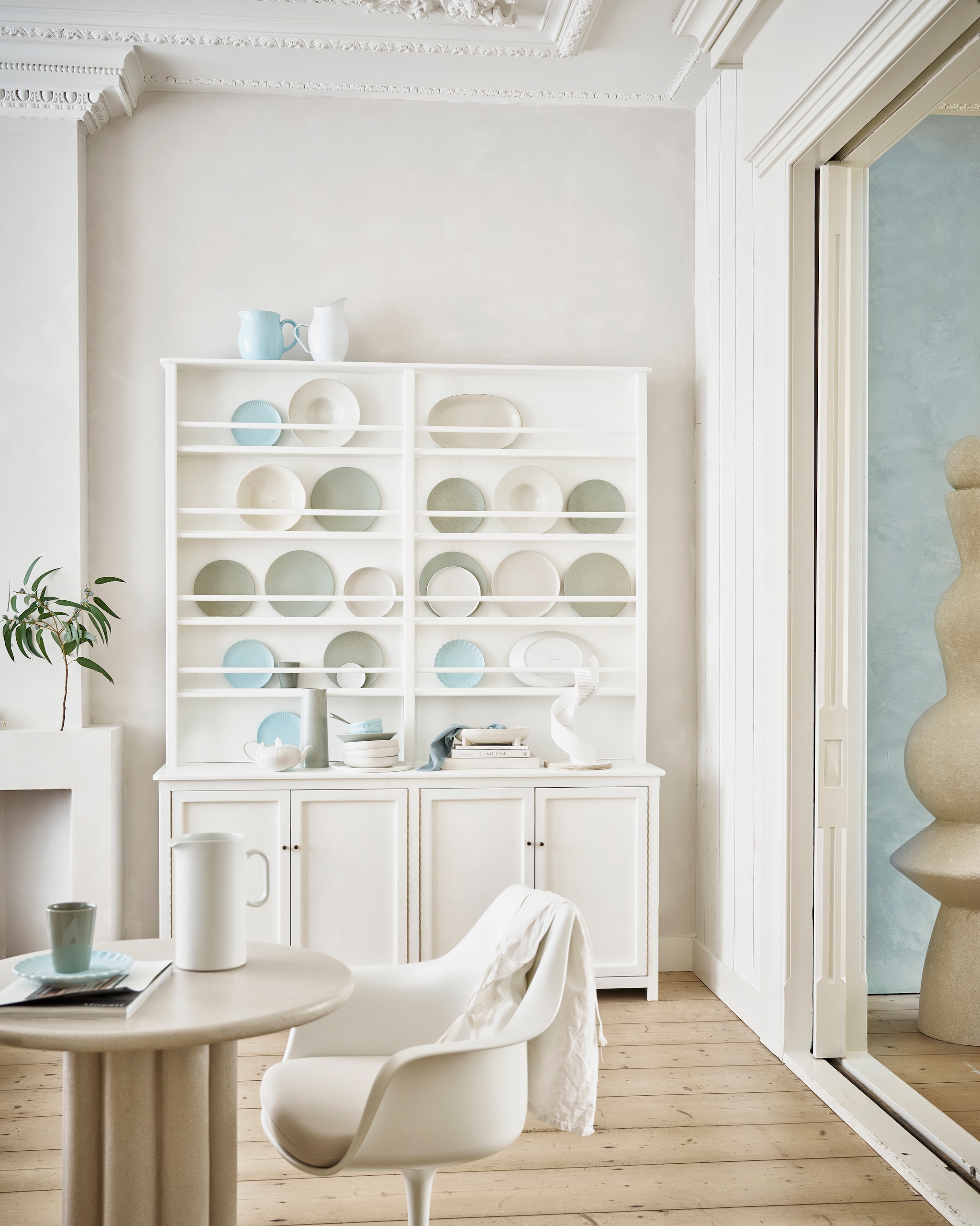 Kast maatwerk, prijs op aanvraag (com-anders.nl), geverfd in Strong White 2001 van Farrow &amp; Ball, 750 ml € 52,- (paint-paper.nl). Bijzettafel, 70 cm (Ø) € 1000,-, XL-object, prijs op aanvraag, (lanena-home.com). Stoel Tulp, glasvezel en metaal € 499,- (marmerentulp.com). Lichtblauwe kan € 49,95, lichtblauwe beker € 10,95, lichtblauwe borden vanaf € 8,95, lichtblauwe schaal € 24,95 (urbannatureculture.com). Stenen kan Redonda € 42,50 (costanova.pt). Blauwe kan € 32,95, witte emaillen kan € 34,95, lichtblauwe ontbijtborden € 9,95, lichtblauwe kommen vanaf € 5,50, theedoek € 6,50 (iblaursen.nl). Keramieken pastaborden Grawa € 42,42, ovale schaal op poten Pemba € 53,03 (nordal.com). Object witte trap, prijs op aanvraag (studiomilo.nl). Gestapelde keramieken borden € 12,99 (hm.com). Muurverf kalkverf IJzig 58, 2,5 liter € 146,90 (lauthentique.nl). Overig kringloop en privébezit. vtwonen 03-2024 | styling Cleo Scheulderman | fotografie Jeroen van der Spek