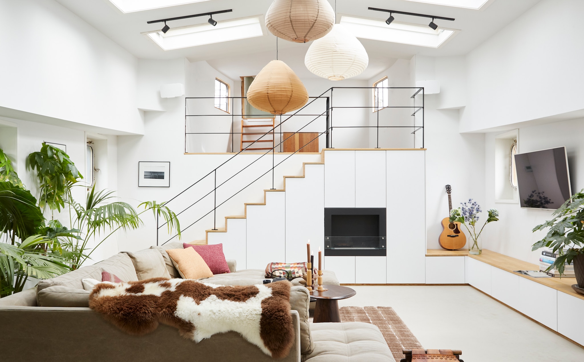 Vloerkleed Blocks van vtwonen, plafondspots SLV van Debasto, wandlampen Barco. Wandkast Francis Christian. Hanglampen HKliving, kunstwerk Micky Hoogendijk, televisie Sony, gitaar Gibson, bank Loods 5, kussens Malagoon, schapenvacht Texelana, bijzettafel uit Uganda, kandelaars Bolia, zandcement vloer met betonverf. Overig onbekend. vtwonen 03-2024 | fotografie Tjitske van Leeuwen | styling Marianne Luning