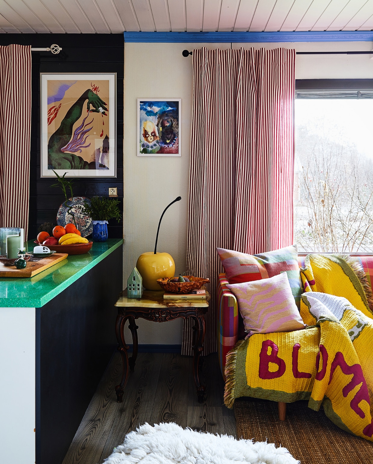 Print aan muur Laura Lehtinen. Object kers, kussens en rood-witte gordijnen Annala. Bank Hakola. Overig onbekend. vtwonen special binnenkijken 121-2024 | productie Living Inside | fotografie Krista Keltanen