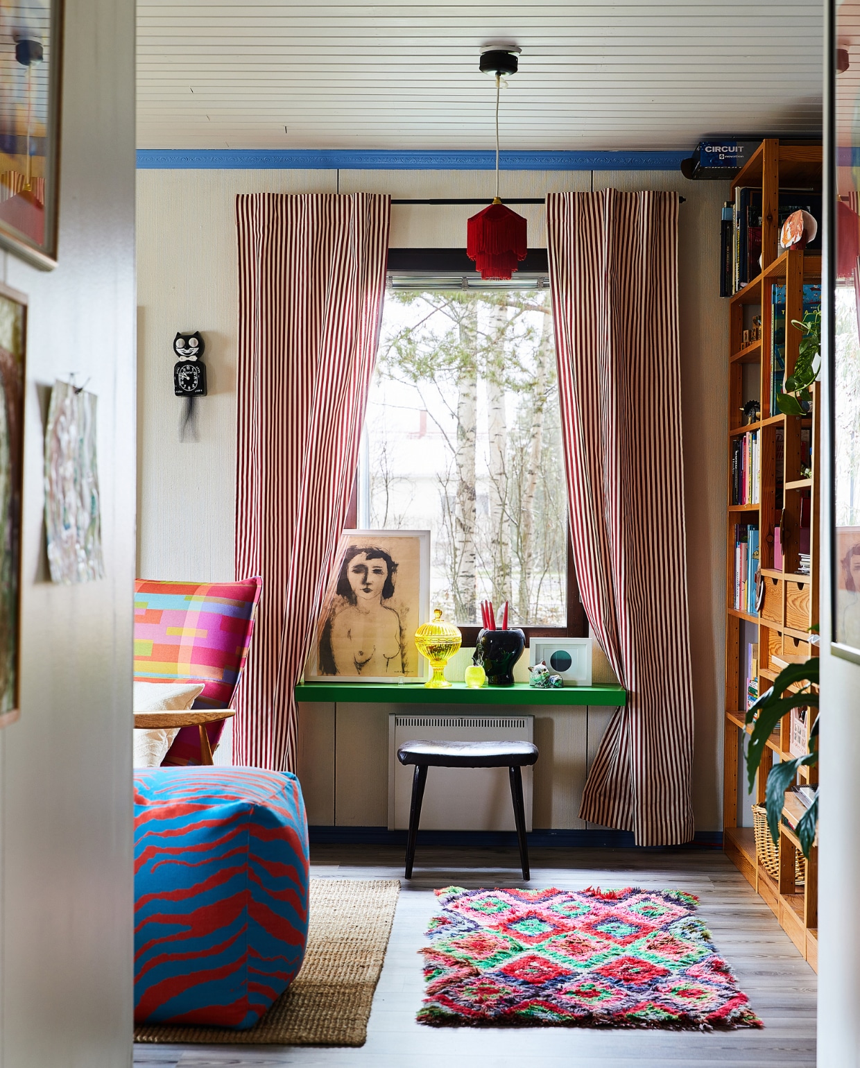 Groene wandplank Lack van Ikea. Fauteuil en poef Adea, gordijnen Annala, vloerkleed Instagram, hang-lamp tweedehands. Overig onbekend. vtwonen special binnenkijken 121-2024 | productie Living Inside | fotografie Krista Keltanen