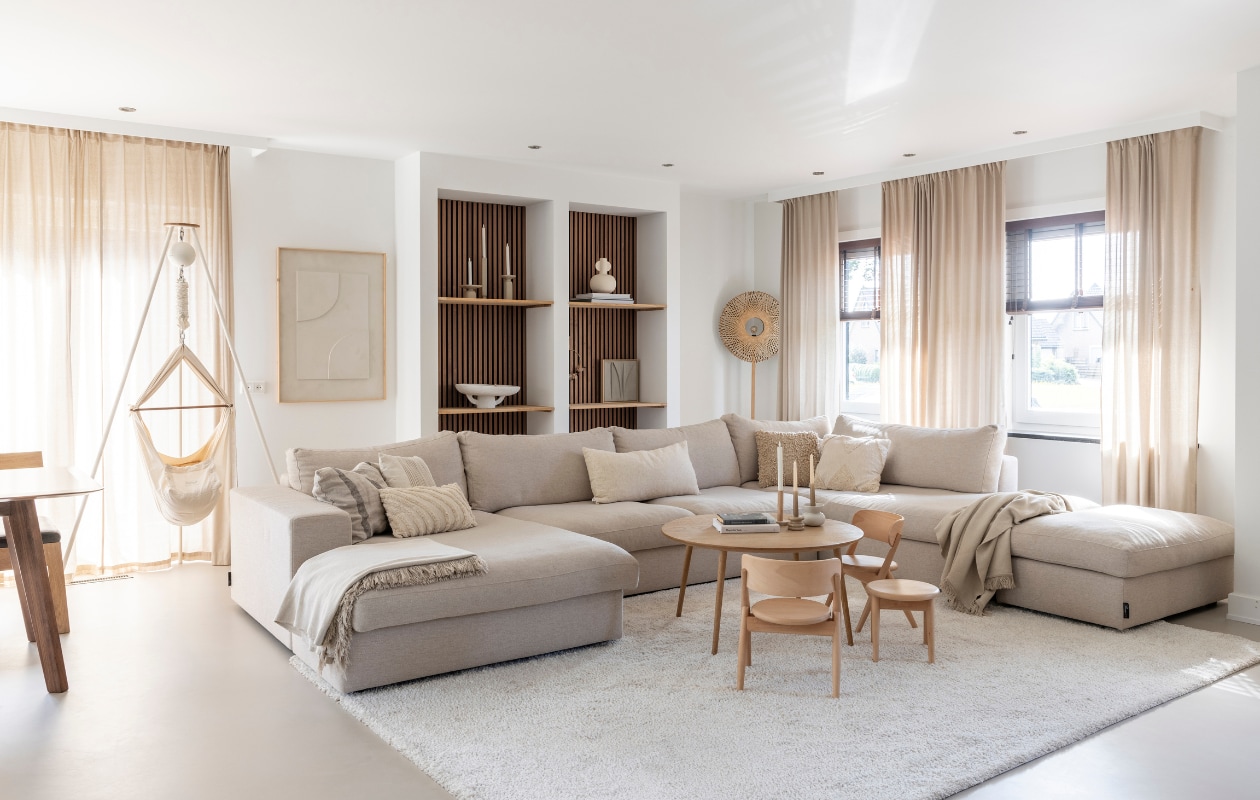 Gietvloer Arturo, muurverf Ral 9016. Gordijnen en wandplanken Karwei. Bamboe jaloezieën Topjaloezieën. Bank, plaids en vloerkleed Room108. Salontafel Via Copenhagen, kandelaars H&amp;M Home, kinderstoelen Curve Lab, babyhangmat Moonboon. Kussens, vaas en kandelaars in kast By-Boo. Schaal Anne-Marie Wonen, wanddecoratie Hout van Toen, wandlamp It’s about RoMi, wandpanelen WoodUpp. Overig onbekend. vtwonen 03-2024 | fotografie Margriet Hoekstra