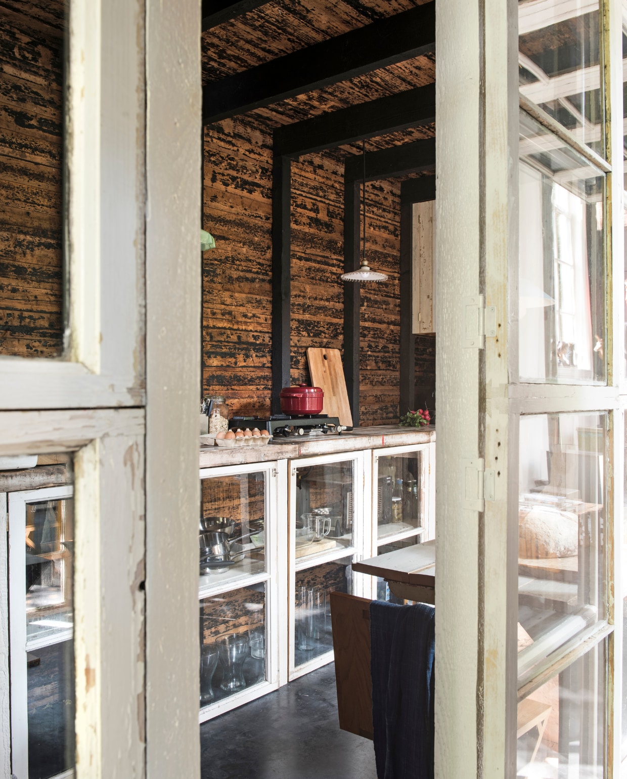 De houten deuren geven toegang tot de afgesloten keuken. vtwonen 03-2017 | styling Inge van Lieshout | fotografie Louis Lemaire/Insidehomepage