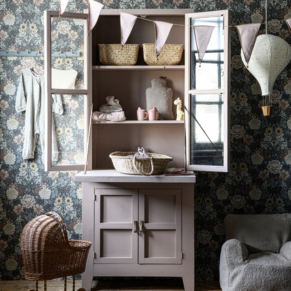 Behang Falsterbo III - Dahlia Garden 7689, 10,05 m, 53 cm breed (borastapeter.com). Vlaggenlijn Bunting Garland van n74 in Dusty Pink, borstel (thearchivestore.com). Kapstok (hm.com), overgeschilderd in grijze betonverf. Jumpsuit Leni van organisch katoen in Silver Grey (thearchivestore.com) Gebreide jersey luierbroek, hangers (zarahome.com). Houten vitrinekast en op maat gemaakte uitklapplank, in krijtverf Dead Salmon van Farrow & Ball (com-anders.nl). Rieten poppenwagen, zeegras manden 25x15 cm, Rubberen giraffe (dille-kamille.nl). Babyhanddoek Efrosini, 75x75 cm, knuffel konijn
(coco-mat.nl). Elektrisch oplaadbare kruik Homey in stof Wooly Crème (stoov.nl). Siliconen drinkbekers, set van 2 (camcamcopenhagen.com). Mozesmand, 70x30 cm (holabb.nl). Katoenen hanglamp (zarahome.com). Zitzak Teddy 1-8 jaar (petiteamelie.nl). vtwonen 02-2023 | styling Marit Saladini | fotografie Louis Lemaire