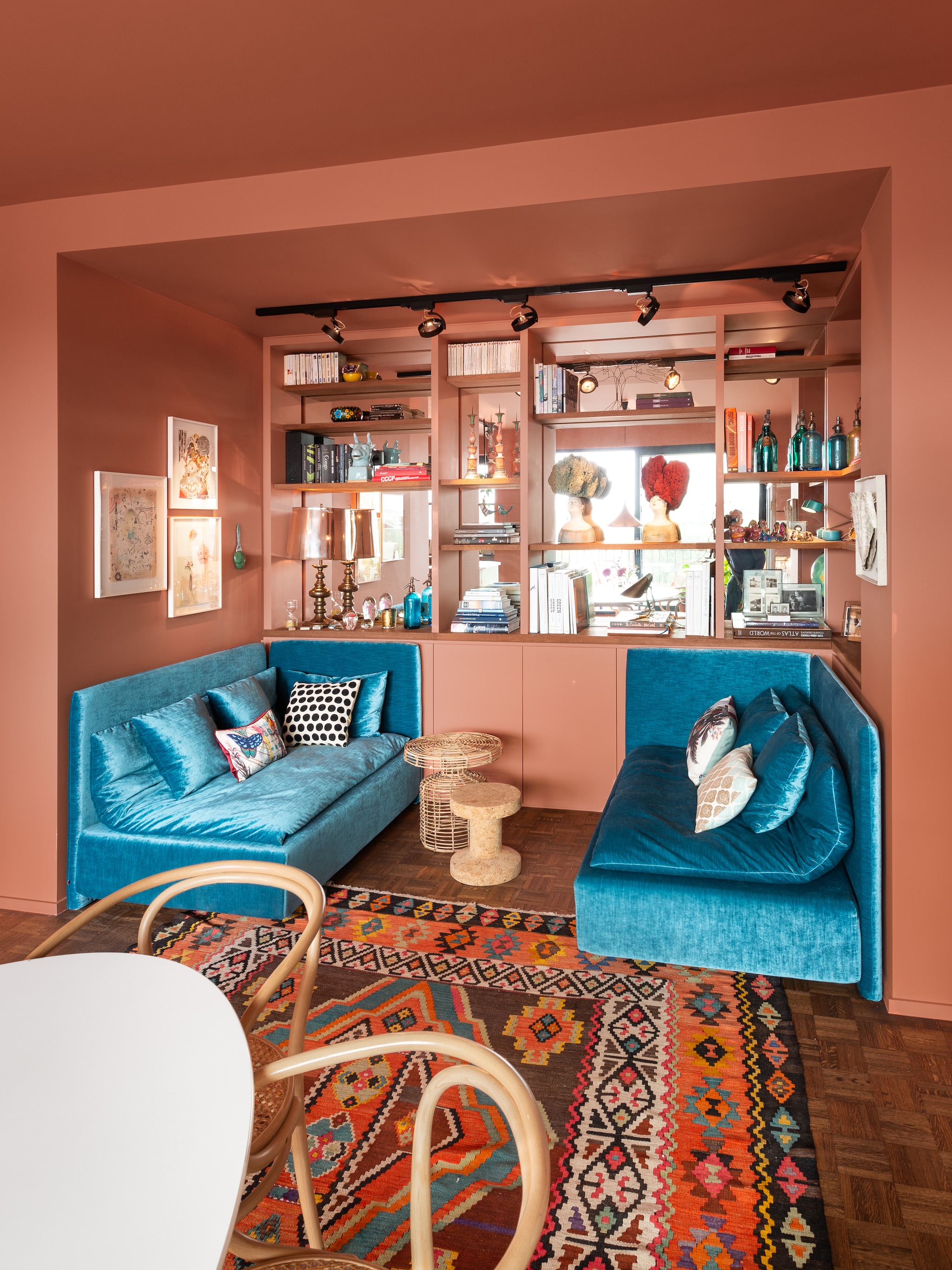 Loungebanken E15, bijzettafel Vitra, rotan bijzettafel House Doctor, verf Red Earth van Farrow en Ball. Kelim en apothekerskast vintage. Vrouwenbeelden Paolo Sandulli. Kunstwerken links Simone Shubuck en Léopoldine Roux. Plafondspots Lampenhuis, tafel Knoll, stoelen 209 van Thonet, overig onbekend. vtwonen 04-2024 | fotografie Mr. Frank | styling Kim Verbist | productie Living Inside