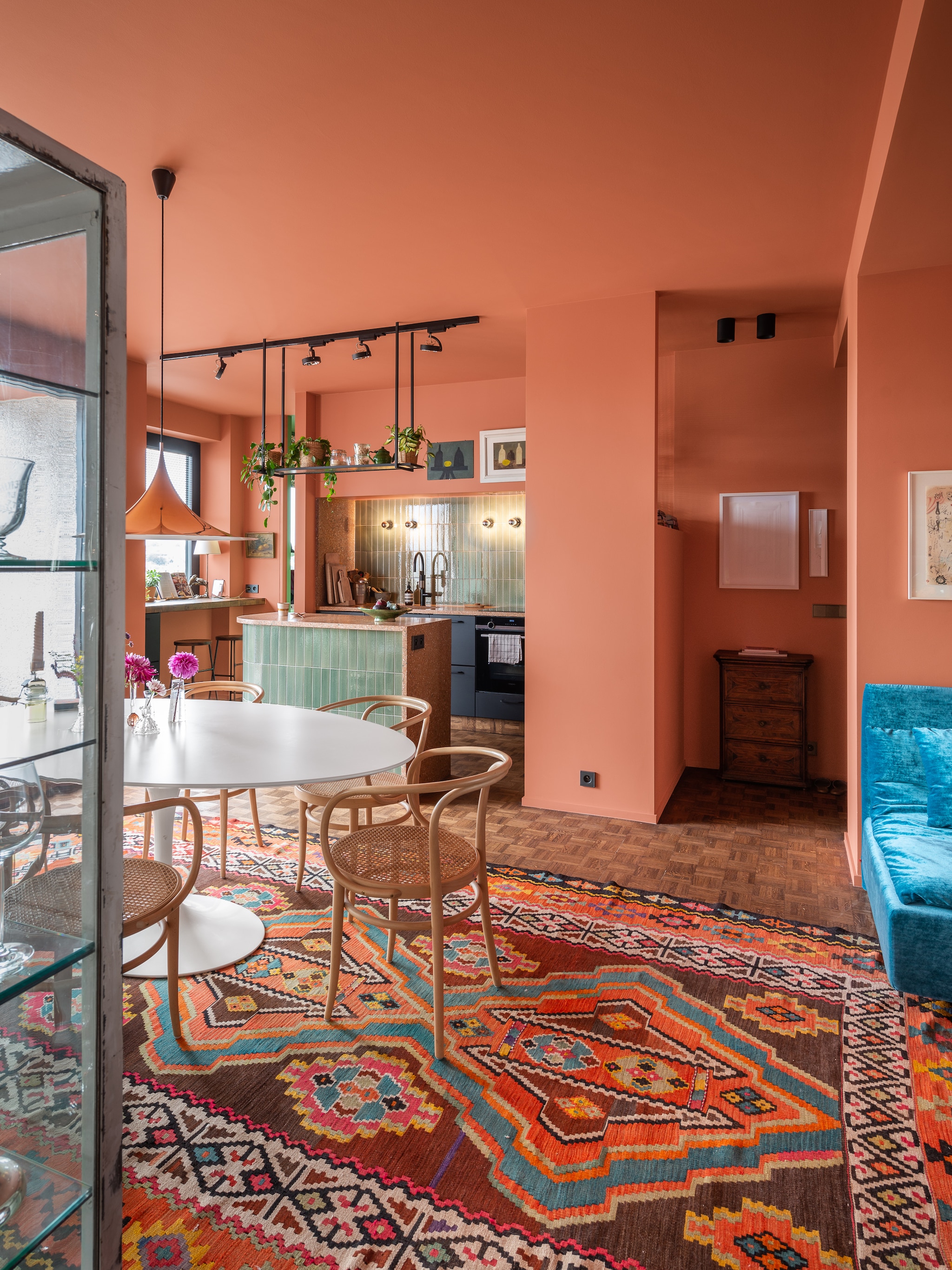 Tafel Knoll, stoelen 209 van Thonet, lamp Gubi, vloerkleed vintage, verf Red Earth van Farrow en Ball. Keuken en klemlamp Ikea. Aanrecht Best Decor, tegels The Winchester Tile Company, vergelijkbare kraan Sanitairwinkel, wandlampen Artemide, krukken Hay, hangrek op maat gemaakt, overig vintage en onbekend. vtwonen 04-2024 | fotografie Mr. Frank | styling Kim Verbist | productie Living Inside