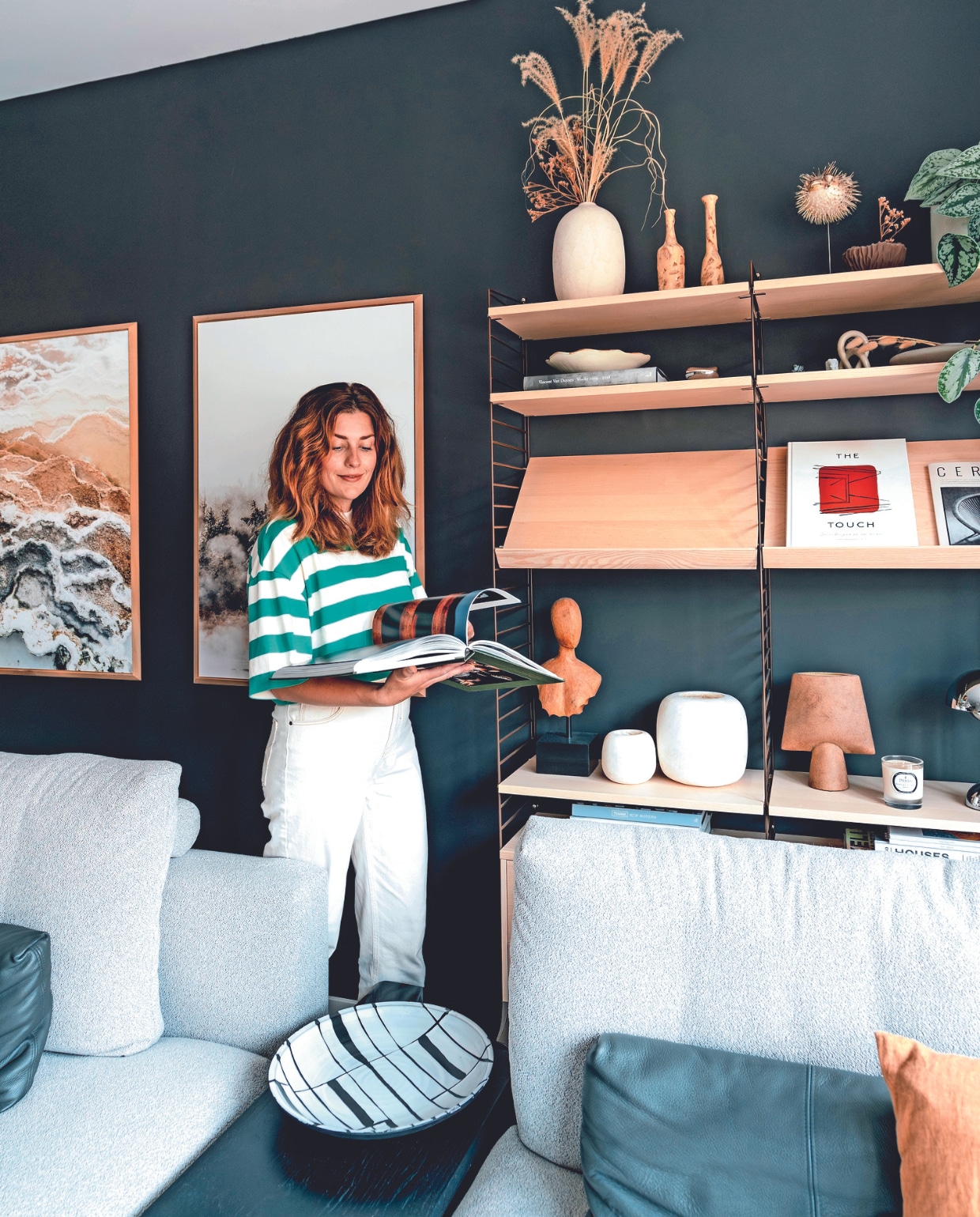 Myrthe in haar nieuwbouwhuis in Berkel en Rodenrijs. Muurkleur Night Sky van Lab Paint, wandkast String Furniture. In de kast: twee kleine vazen en schaal uit keramiekshop in Zuid-Frankrijk, platte vaas Bolia. Boeken: Tales from the Roads Less Travel, Vincent van Duysen Works 2009-2018, The Touch: Spaces designed for the Senses, Think New Modern. Alabaster theelichten Enter the Loft, bruine vaas 101 Copenhagen, geurkaars Parks London, modulaire bank Rolf Benz, baklijsten Goedman Lijstenmakerij met eigen fotografie. Overig onbekend. vtwonen 02-2024 | fotografie Myrthe Slootjes | tekst Mirjam Rosema-Verhulst