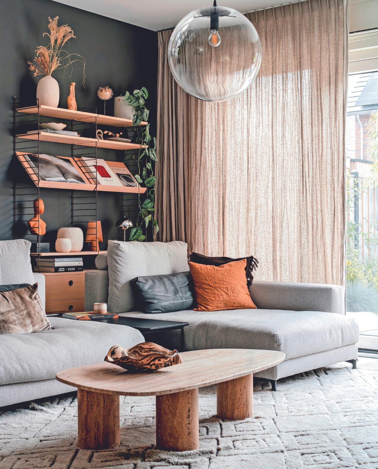 Muurkleur Night Sky van Lab Paint, linnen gordijnen Flax van By Mölle, wandkast String Furniture. In de kast: twee kleine vazen en schaal keramiekshop in Zuid-Frankrijk, plant Scindapsus Spikkel, platte vaas Bolia, alabaster theelichten Enter the Loft, bruine vaas 101 Copenhagen, tafellamp Flowerpot van &amp;Tradition. Linnen kussen By Mölle, kelim kussen Ferm Living, velvet kussen Claudi. Modulaire bank, leren kussens en bijzettafel Rolf Benz. Salontafel Thomtable no. 02 van Thomstudio, keramieken kop Atelier van Schaijck, schaal Wave van Putzy Ceramics, vloerkleed Armadillo, hanglamp Selene van ClassiCon. Overig onbekend. vtwonen 02-2024 | fotografie Myrthe Slootjes