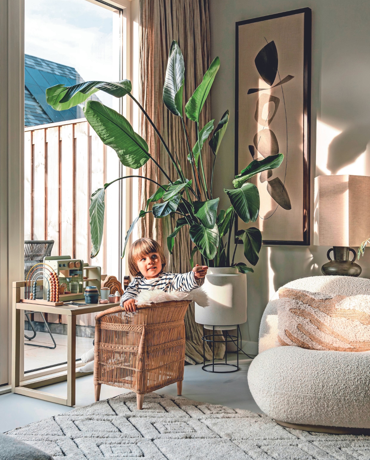 Muurkleur Ammonite van Lab Paint, vloer beton ciré van Boncreations, linnen gordijnen Flax van By Mölle, kunst Symbiose van Atelier De Rijk, pot met standaard Bolia, plant Strelitzia, kinderbureau Little Architect van Ferm Living, kinderstoel Malawi van People of the Sun, speelgoedkeuken Ikea. Telraam en koffiezetapparaat Little Dutch. Fauteuil Pacha van Gubi, kussen HKliving, vloerkleed Armadillo, stoel buiten Grace van Exotan. vtwonen 02-2024 | fotografie Myrthe Slootjes | tekst Mirjam Rosema-Verhulst