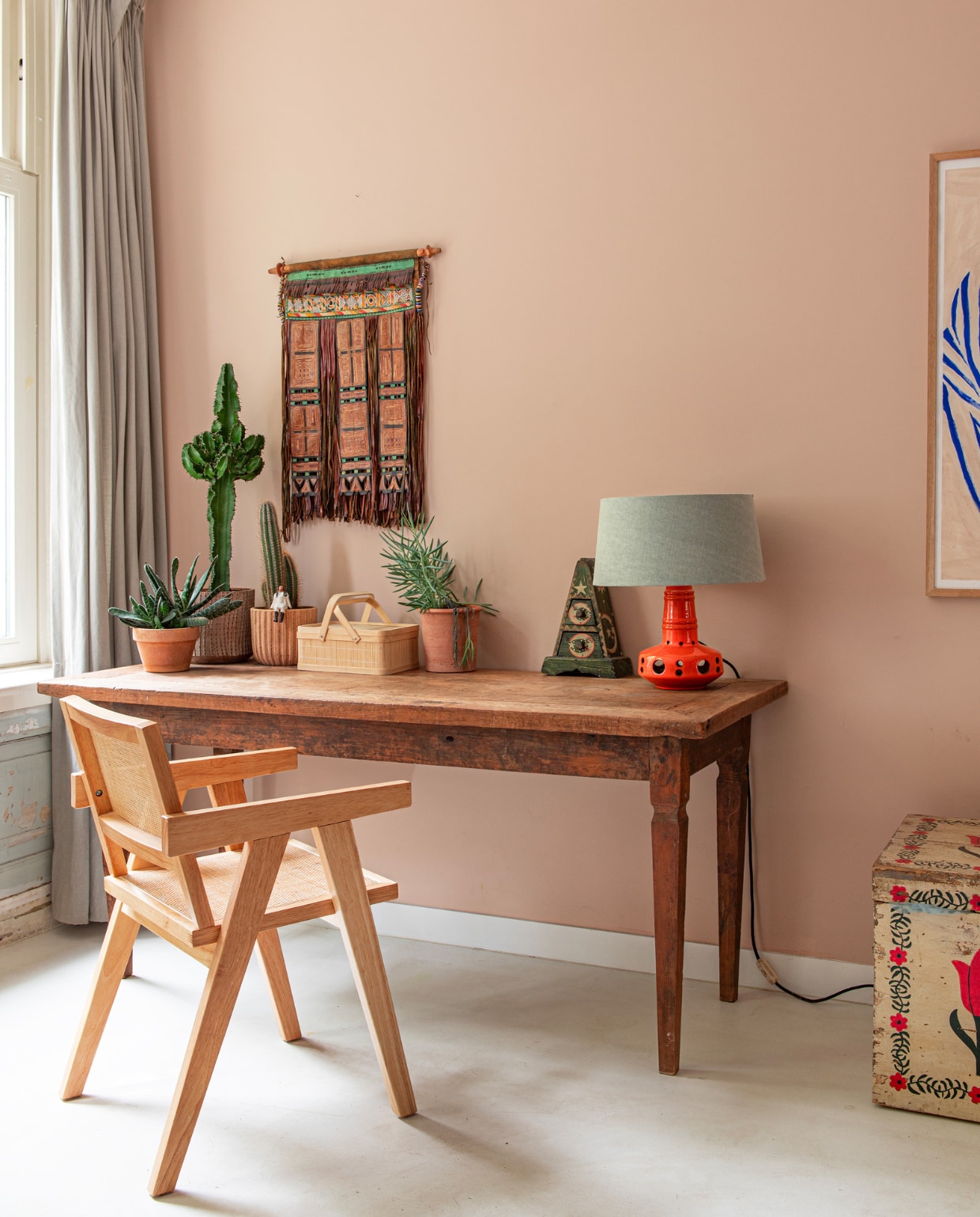 Muurverf Setting Plaster van Farrow &amp; Ball. Stoel Kwantum, tafel gekregen van oom, driehoekig kastje via Instagram, wanddecoratie van leer van de Toeareg uit de Sahara. Schilderij Sofia Lind, kist Van Dijk &amp; Ko. Overig onbekend. vtwonen special binnenkijken 121-2023 | productie De Binnenkijkers | styling Jeske Weel | fotografie Caroline Coehorst