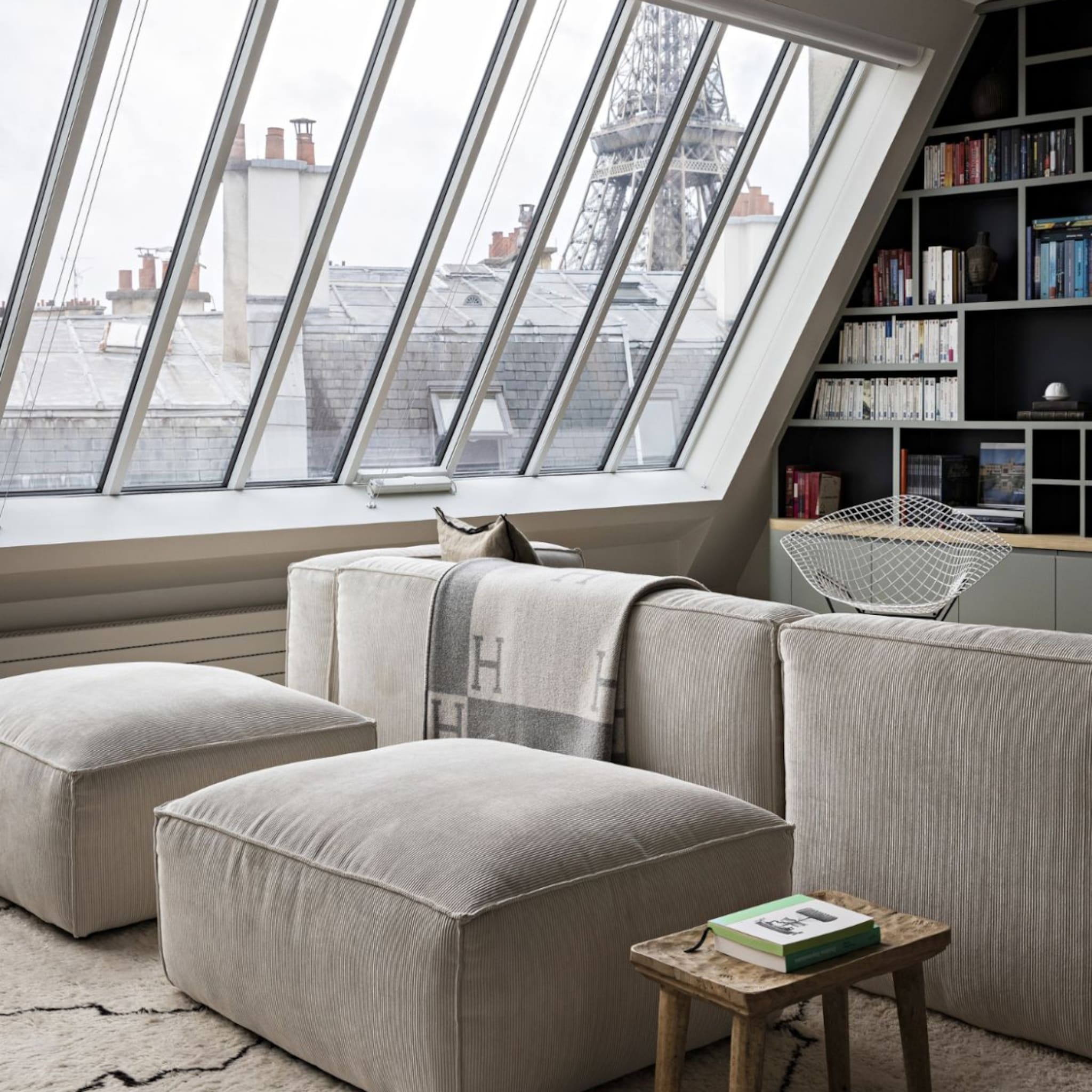 Appartement met grijze bank en uitzicht op de Eiffeltoren