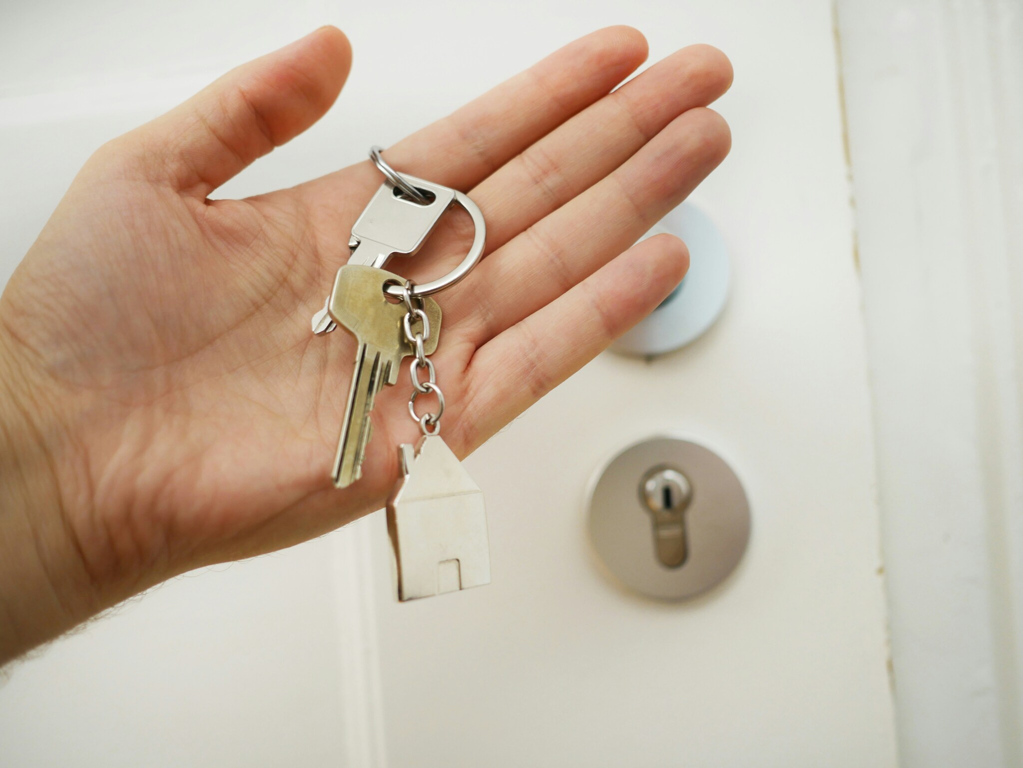 Huissleutels in hand bij voordeur Fotografie Maria Ziegler (via Unsplash)