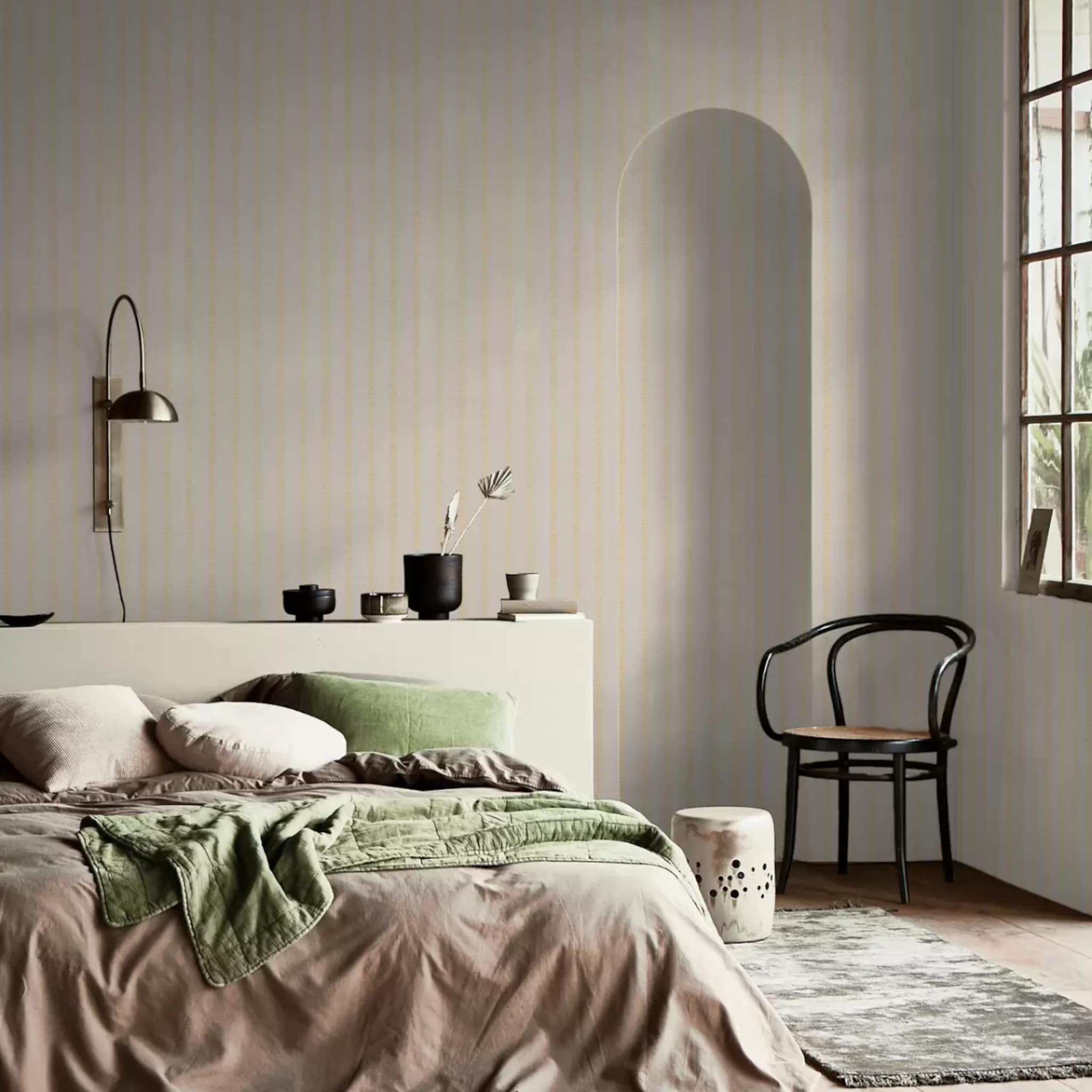 Slaapkamer met vliesbehang en een gouden wandlamp