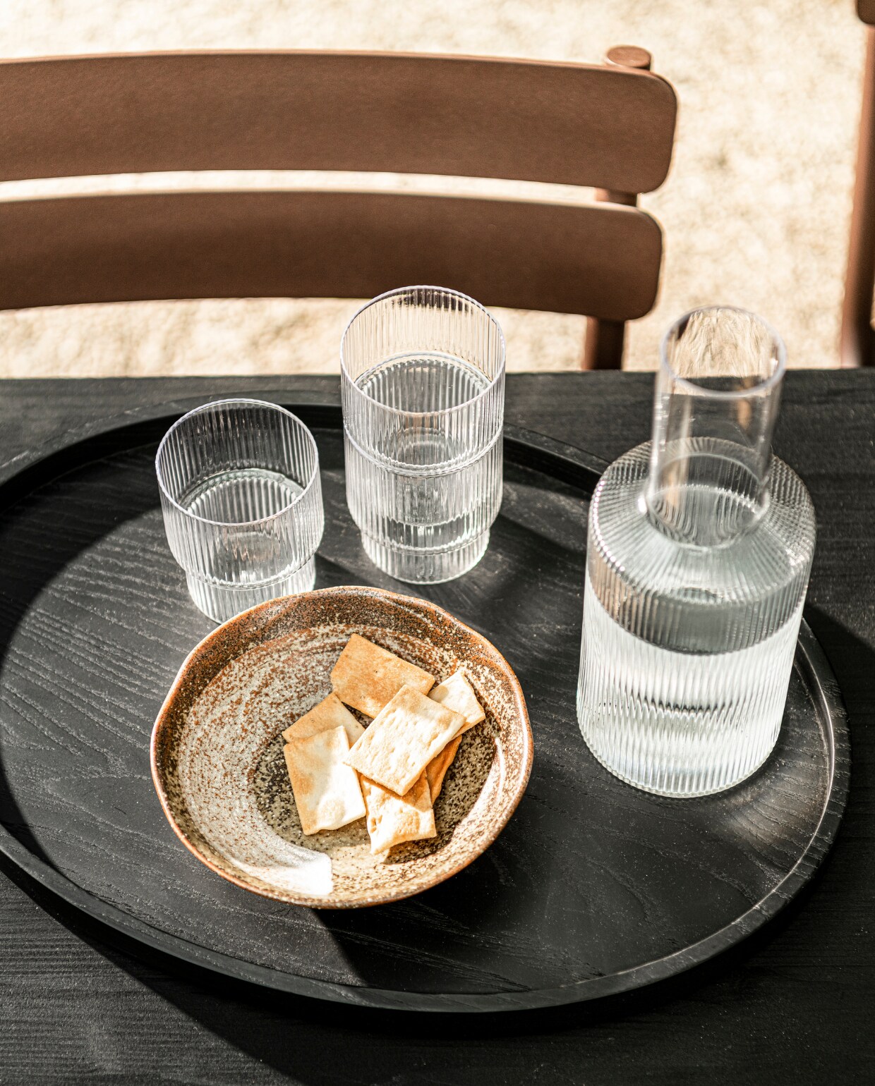 Ripple glazen van Ferm Living, set van 4 € 36,- Ripple karaf van Ferm Living € 35,-, zwart dienblad Vincent van Duysen voor Serax € 89,-, keramieken Japanse kom van HKliving, set van 4 € 39,95 (vtwonen.nl). vtwonen 06-2021 | productie &amp; styling Kim van Rossenberg | uitvoering Richard van Meerveld | fotografie Sjoerd Eickmans